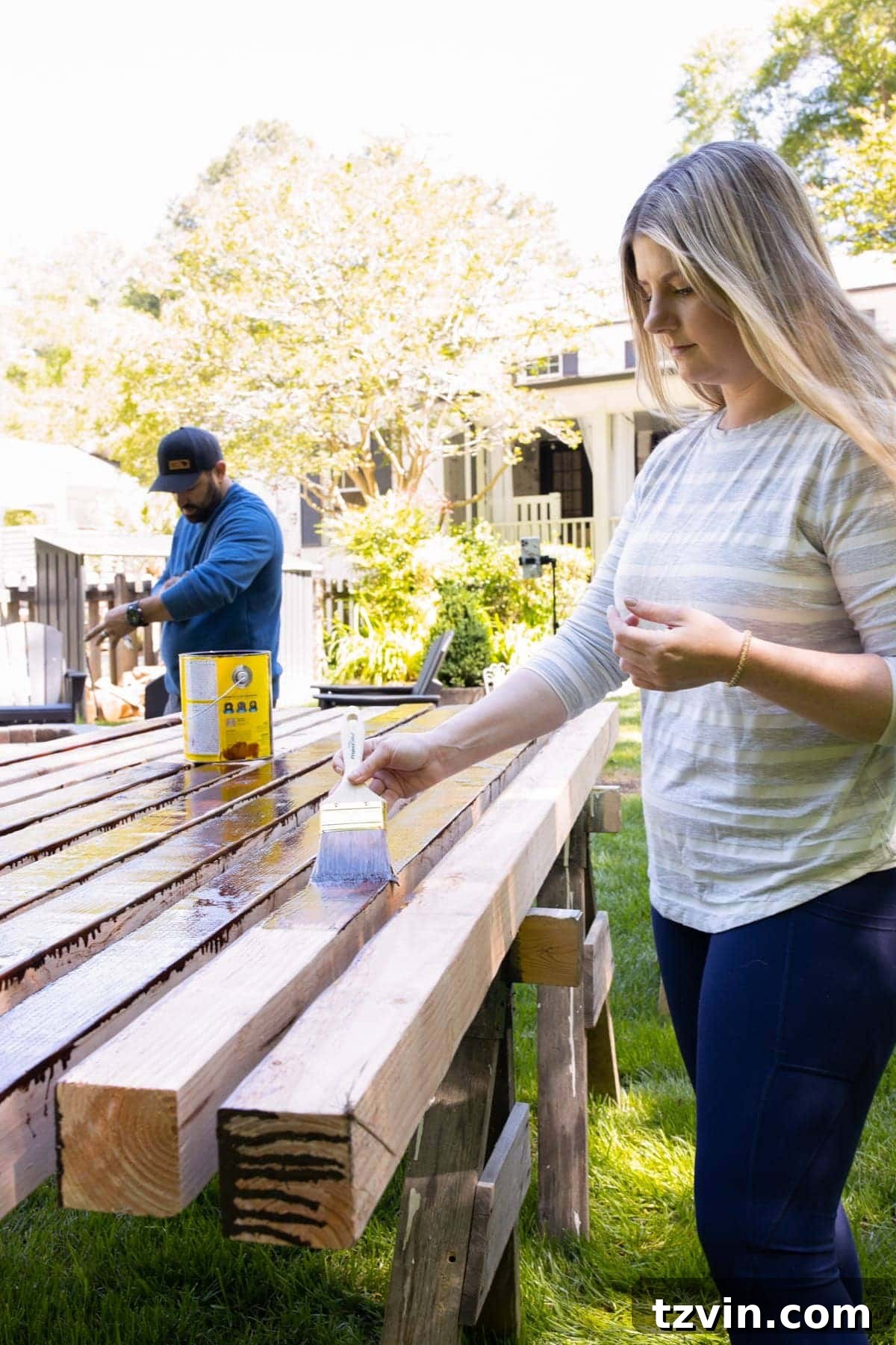 applying waterproofing stain to 4x4 cedar wood boards