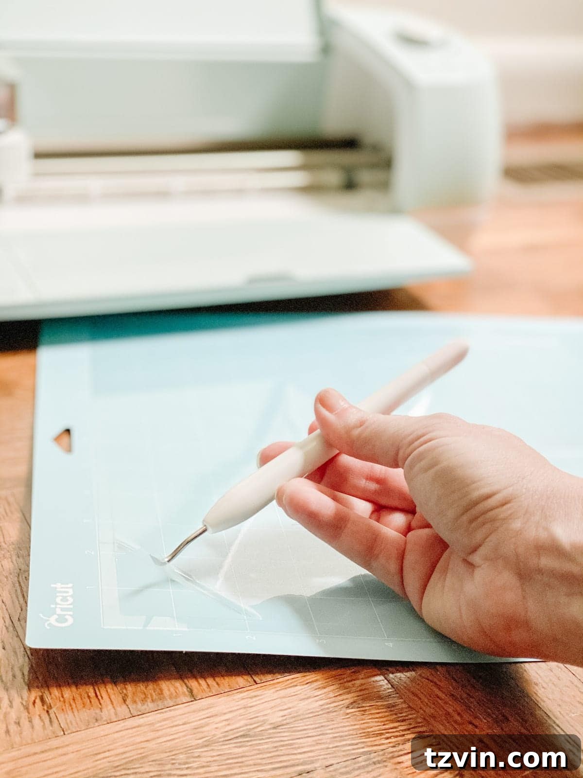 Carefully peeling the acetate stencil from the Cricut mat