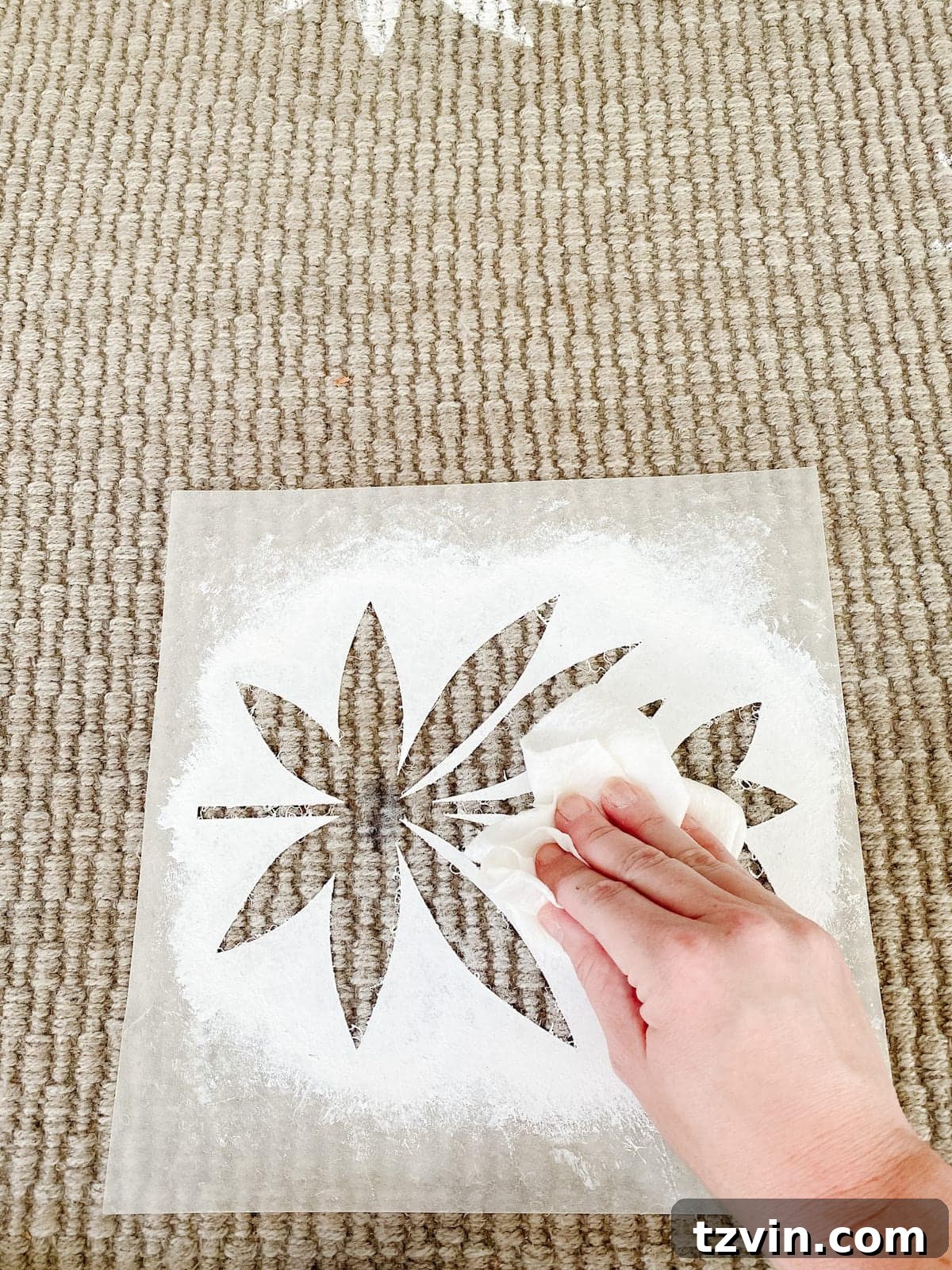 Positioning the floral stencil on the outdoor rug