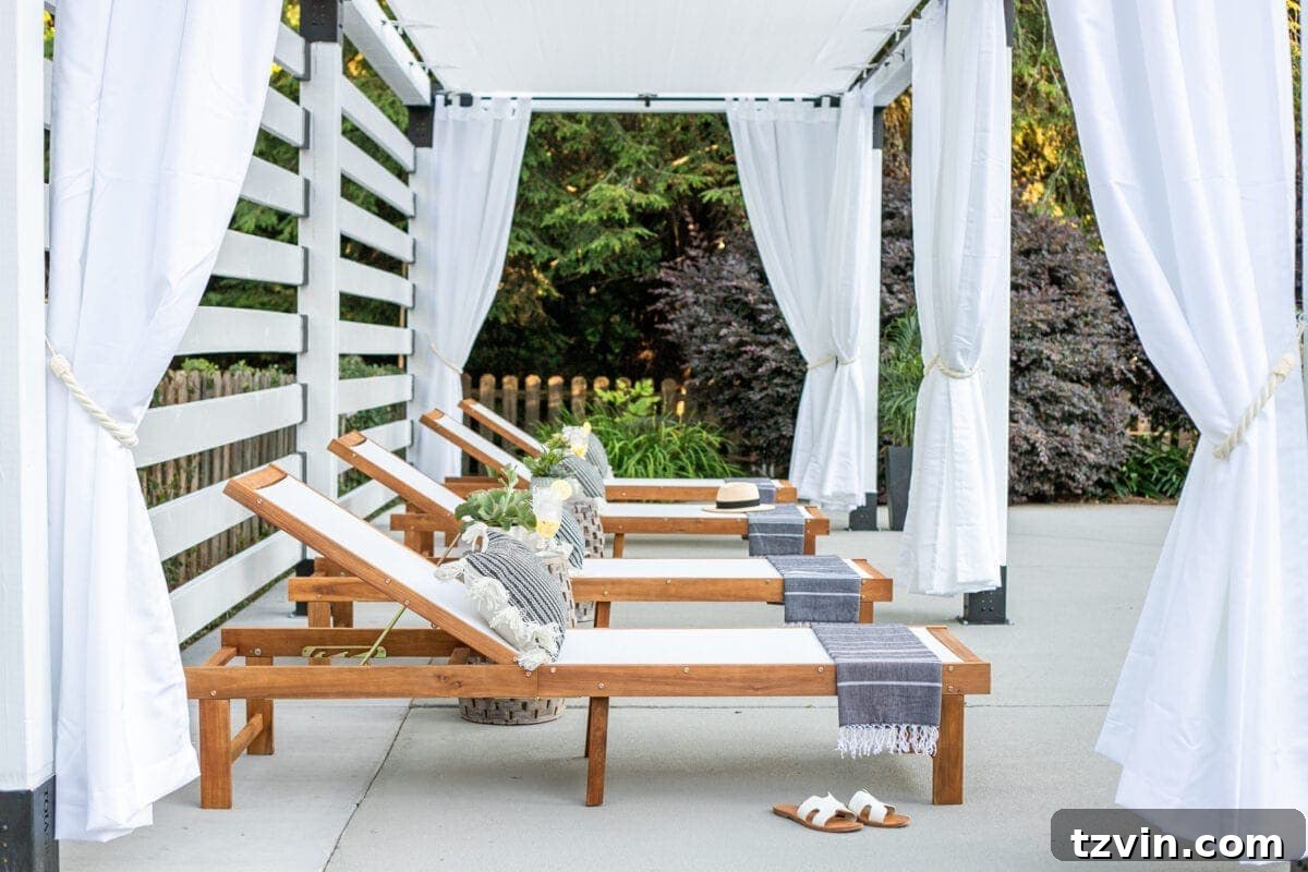 white DIY pergola cabana with outdoor curtains and lounge chairs