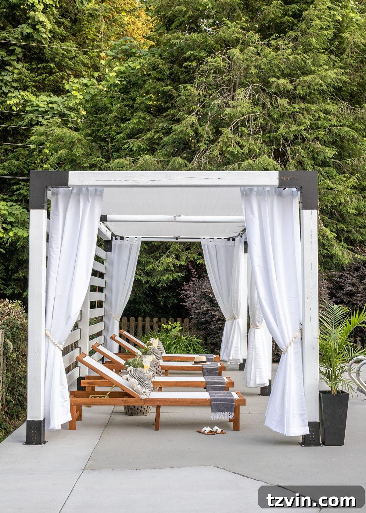 white DIY pergola cabana with outdoor curtains and lounge chairs