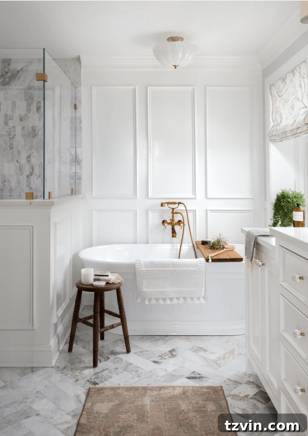 Picture frame molding in a bathroom with soaking tub and herringbone tile