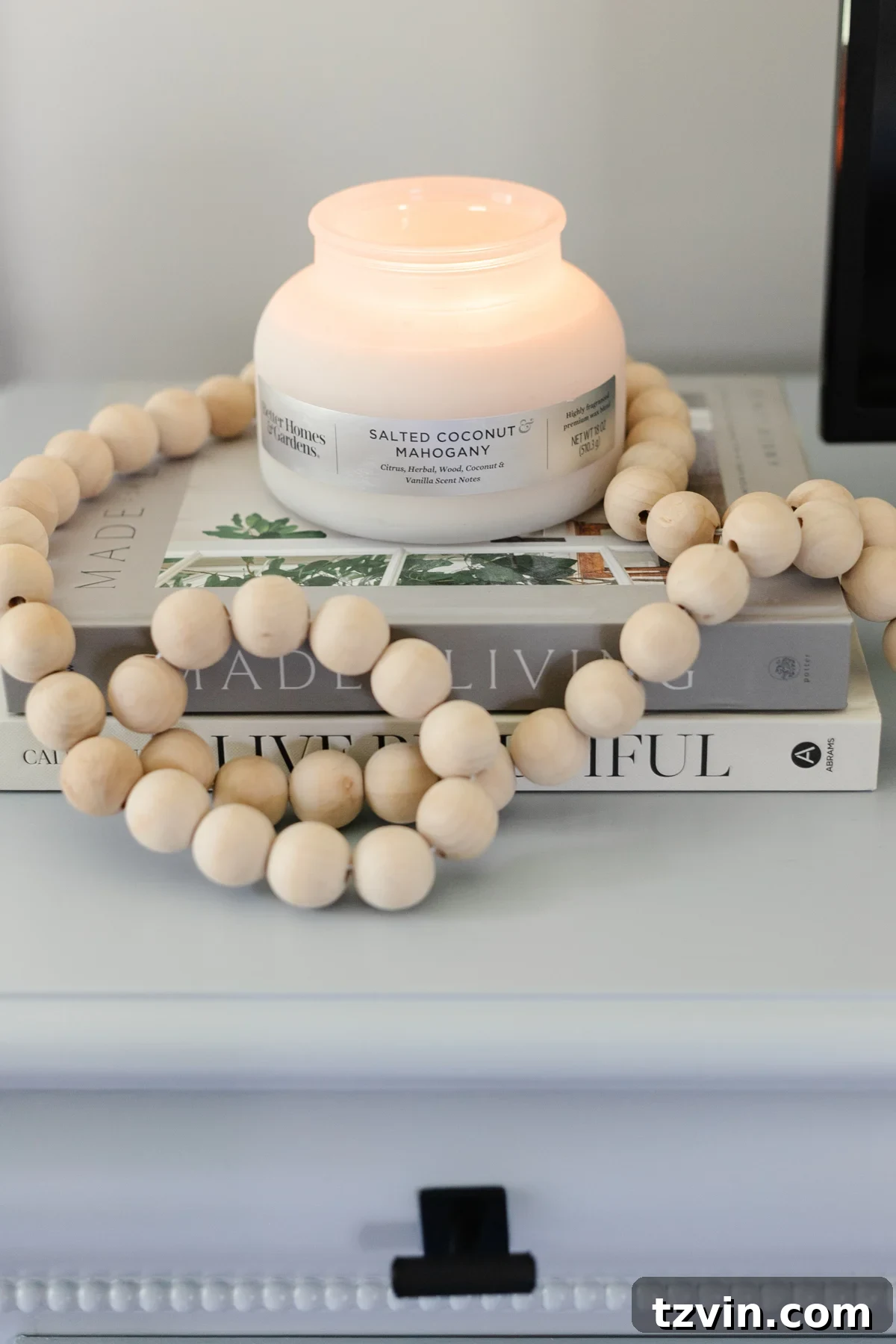 10 Clever Tricks to Make Your Small Bedroom Seem Bigger 11 candle with wooden beads and book stack on dresser