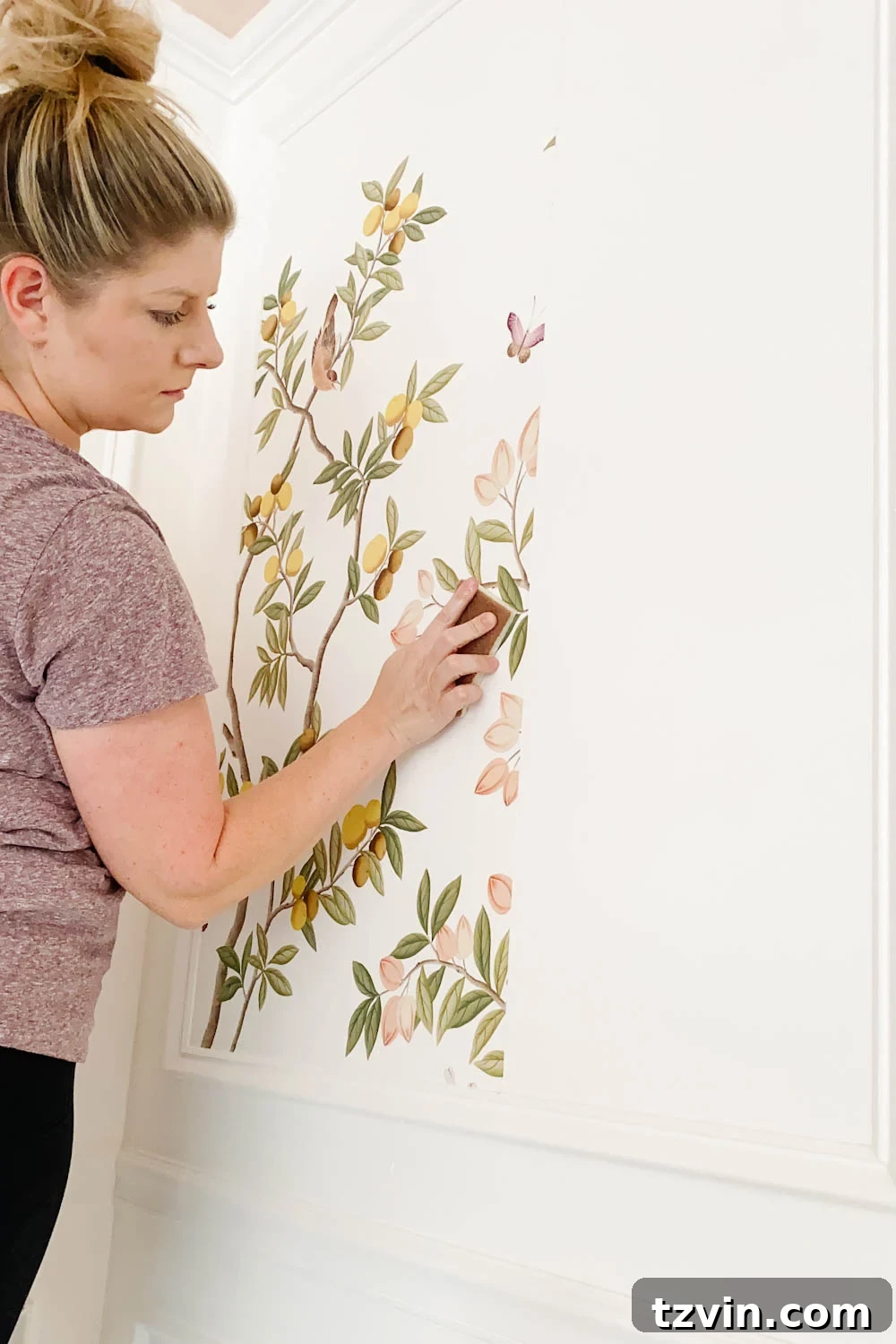 Create a Designer Look: Wallpapering Inside Picture Frame Molding 14 Wiping down the pasted wallpaper with a damp sponge to remove any excess paste, ensuring a clean finish.