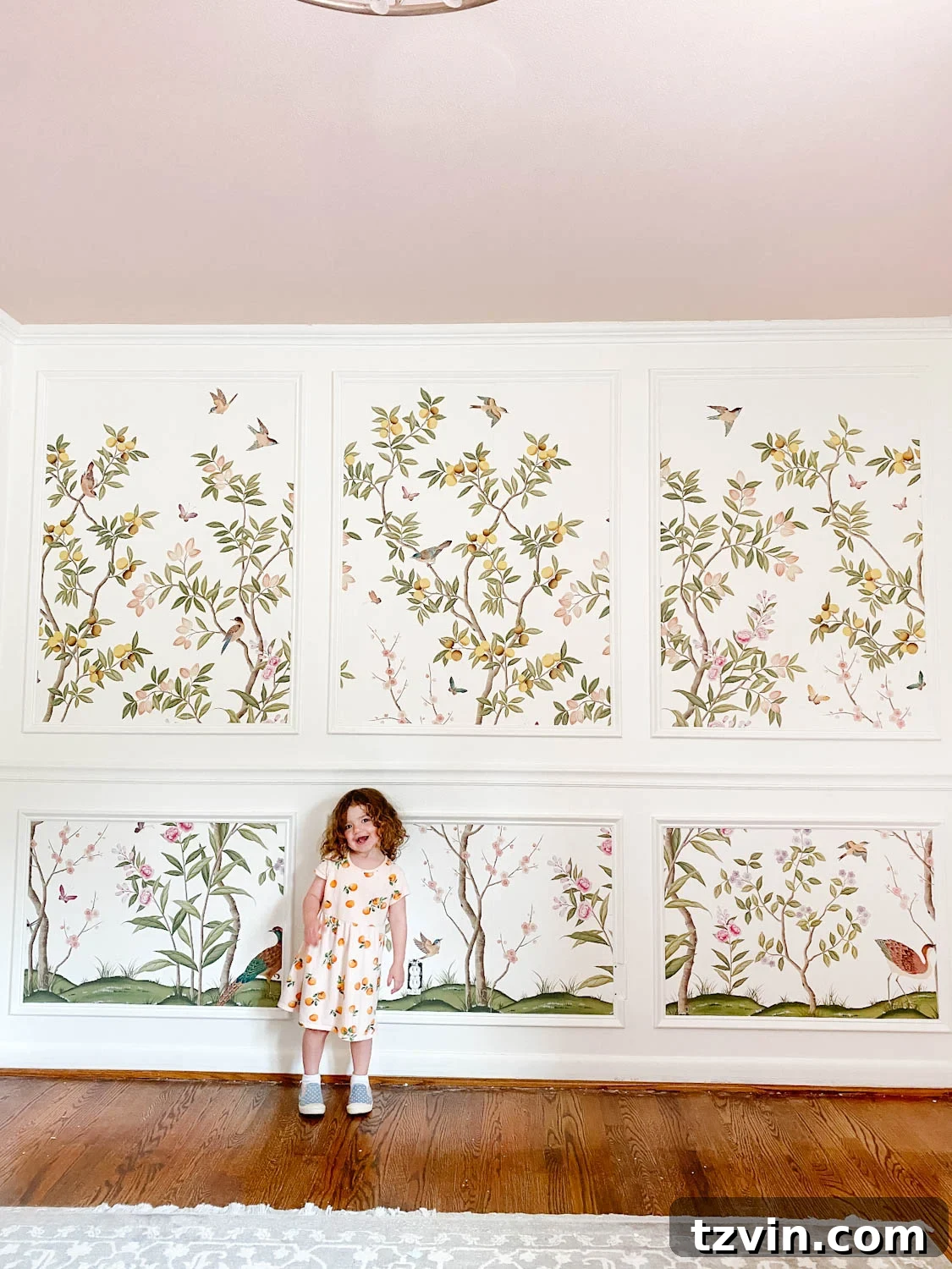 Create a Designer Look: Wallpapering Inside Picture Frame Molding 15 A happy little girl, Regan, smiles next to her newly installed chinoiserie wallpaper mural framed by picture frame molding in her bedroom.