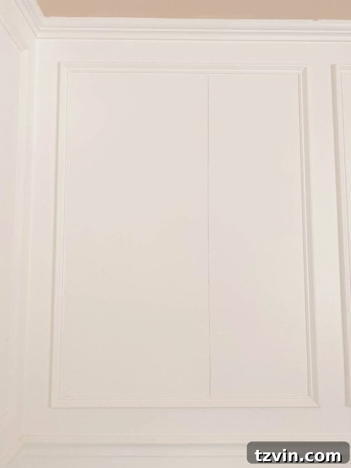 Create a Designer Look: Wallpapering Inside Picture Frame Molding 6 Using a plumb line and pencil to mark a perfectly vertical starting line on the wall inside picture frame molding for wallpaper.