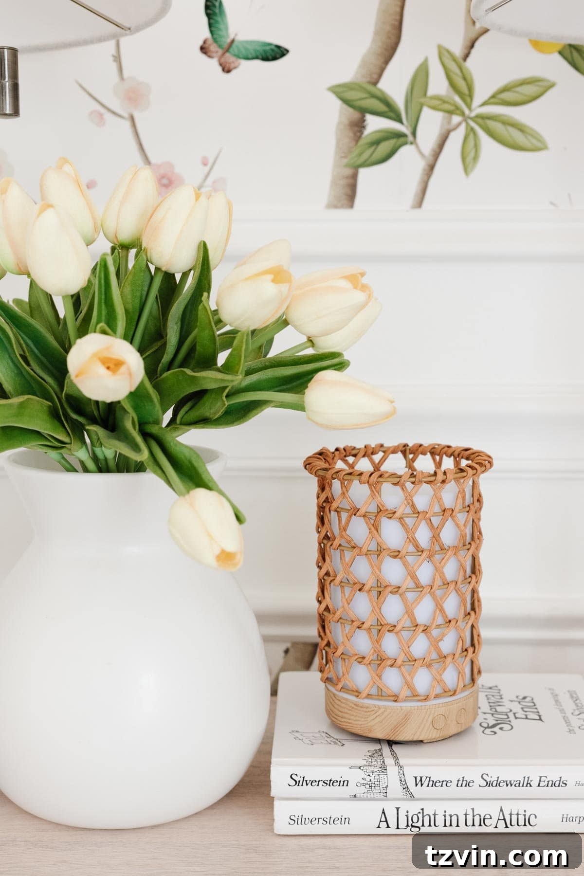 white vase of flowers with rattan diffuser