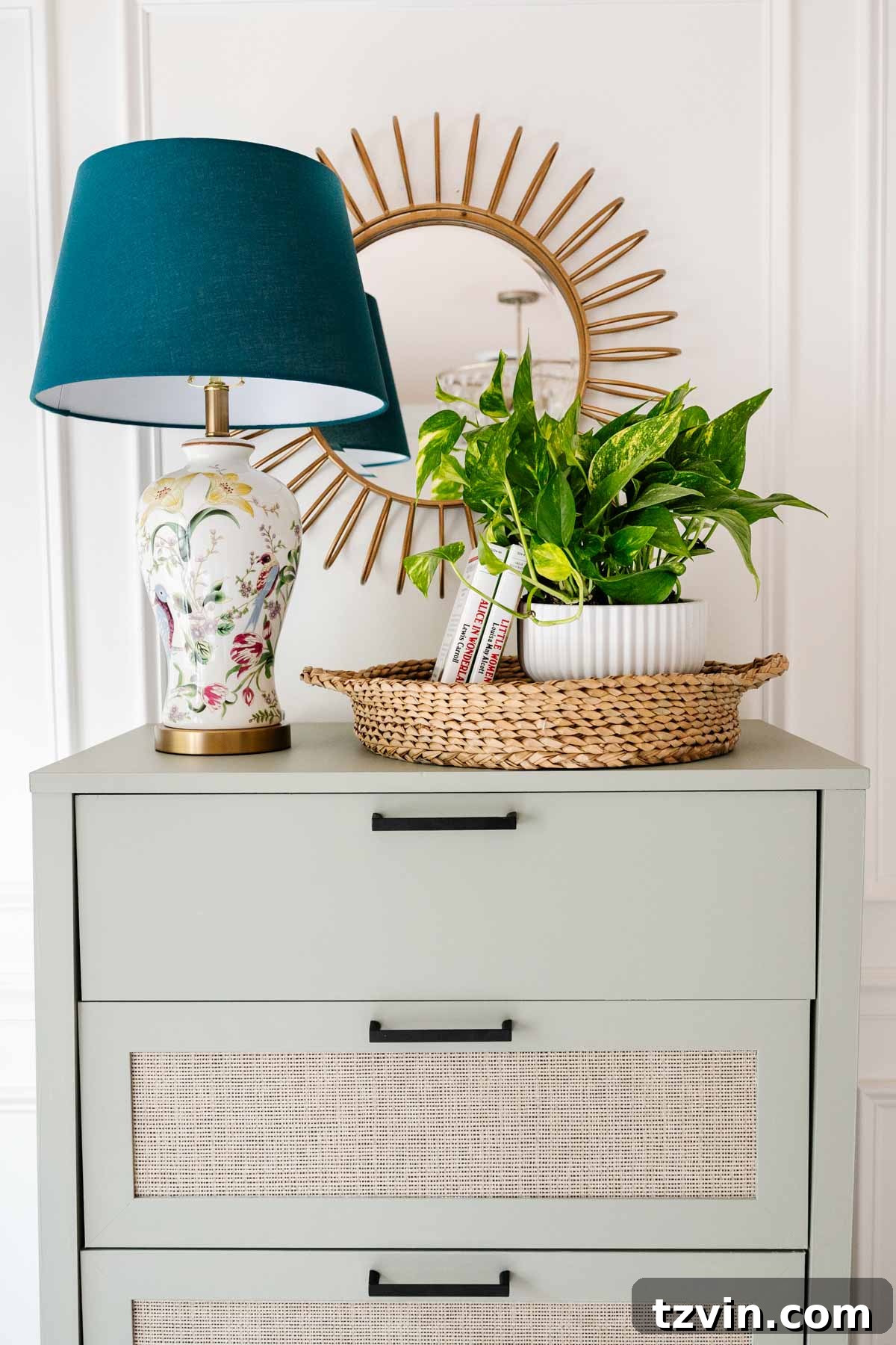 Charming sunburst mirror and other decorative items atop a newly painted dresser in a kid's room.