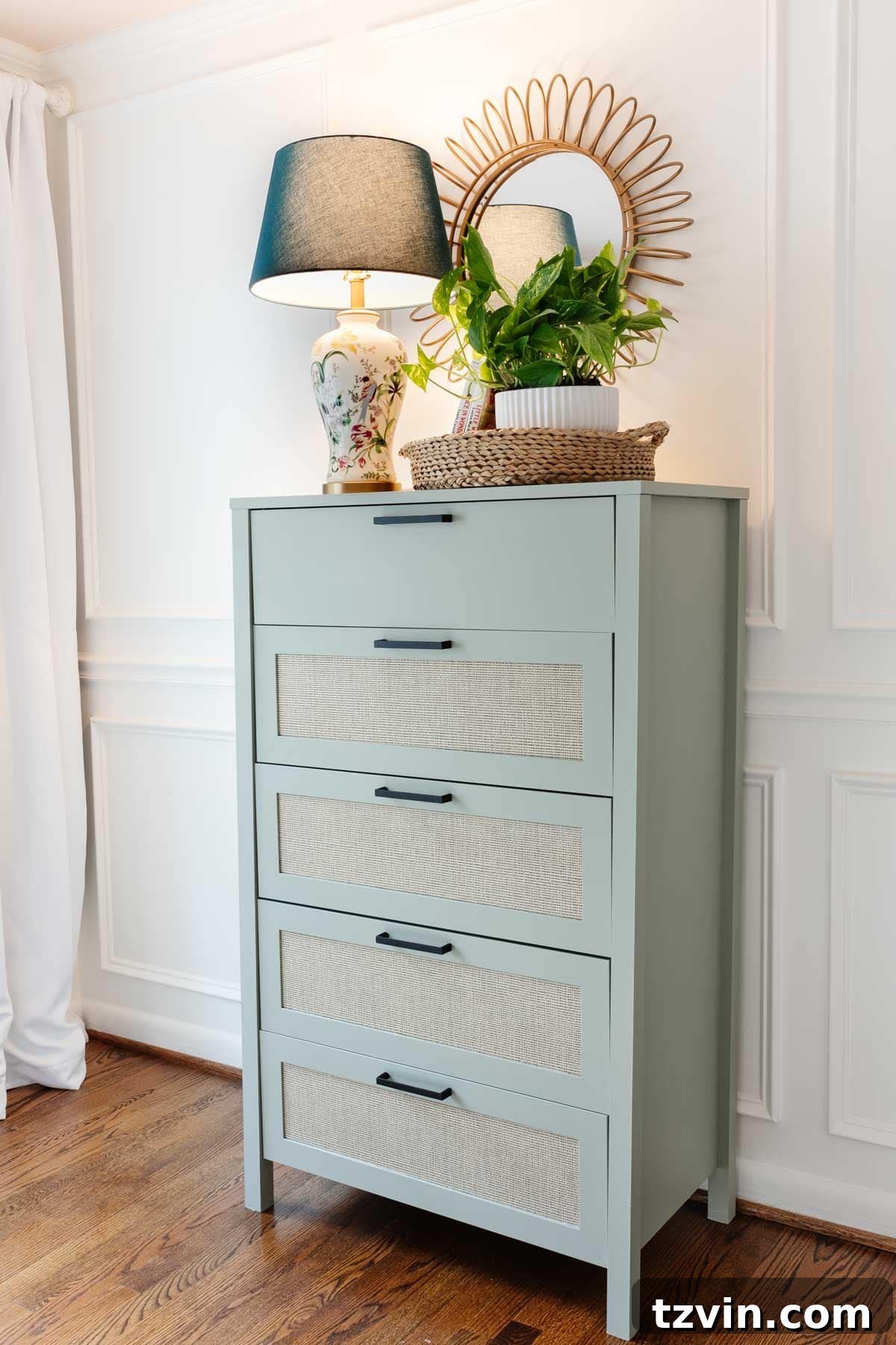 Sage green painted dresser with cane detailing as a beautiful and functional piece in a little girl's room.