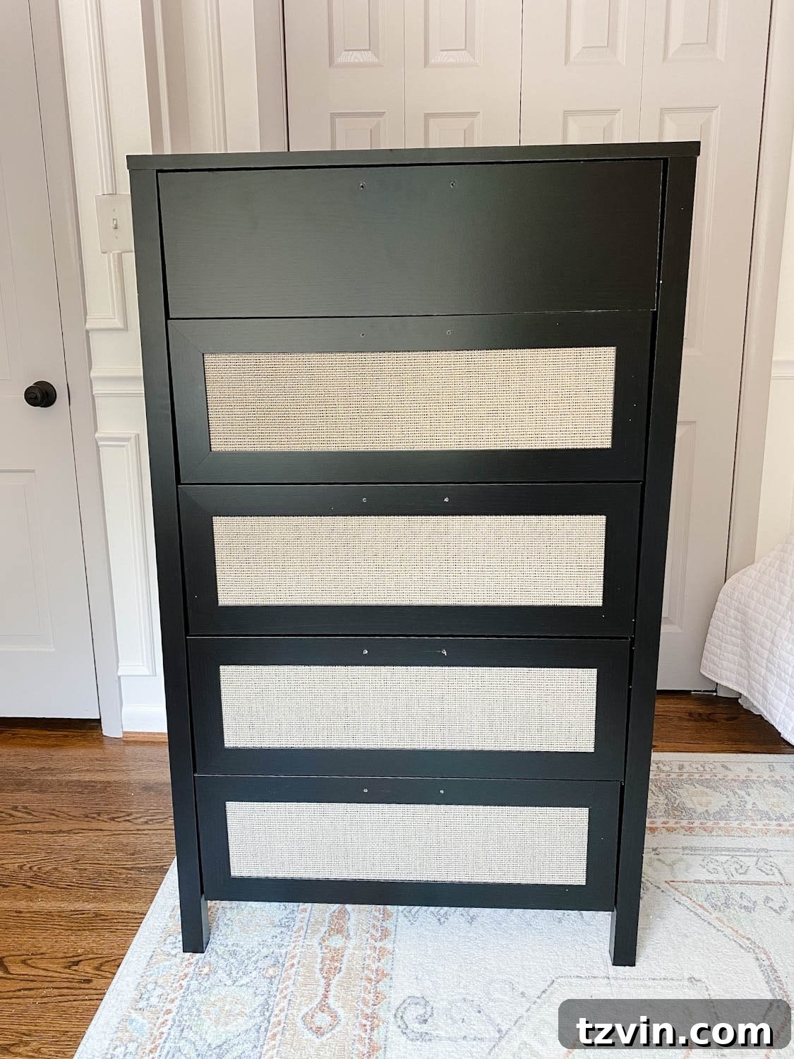 Black laminate dresser with elegant faux cane webbing details on the drawers, ready for a DIY paint makeover.
