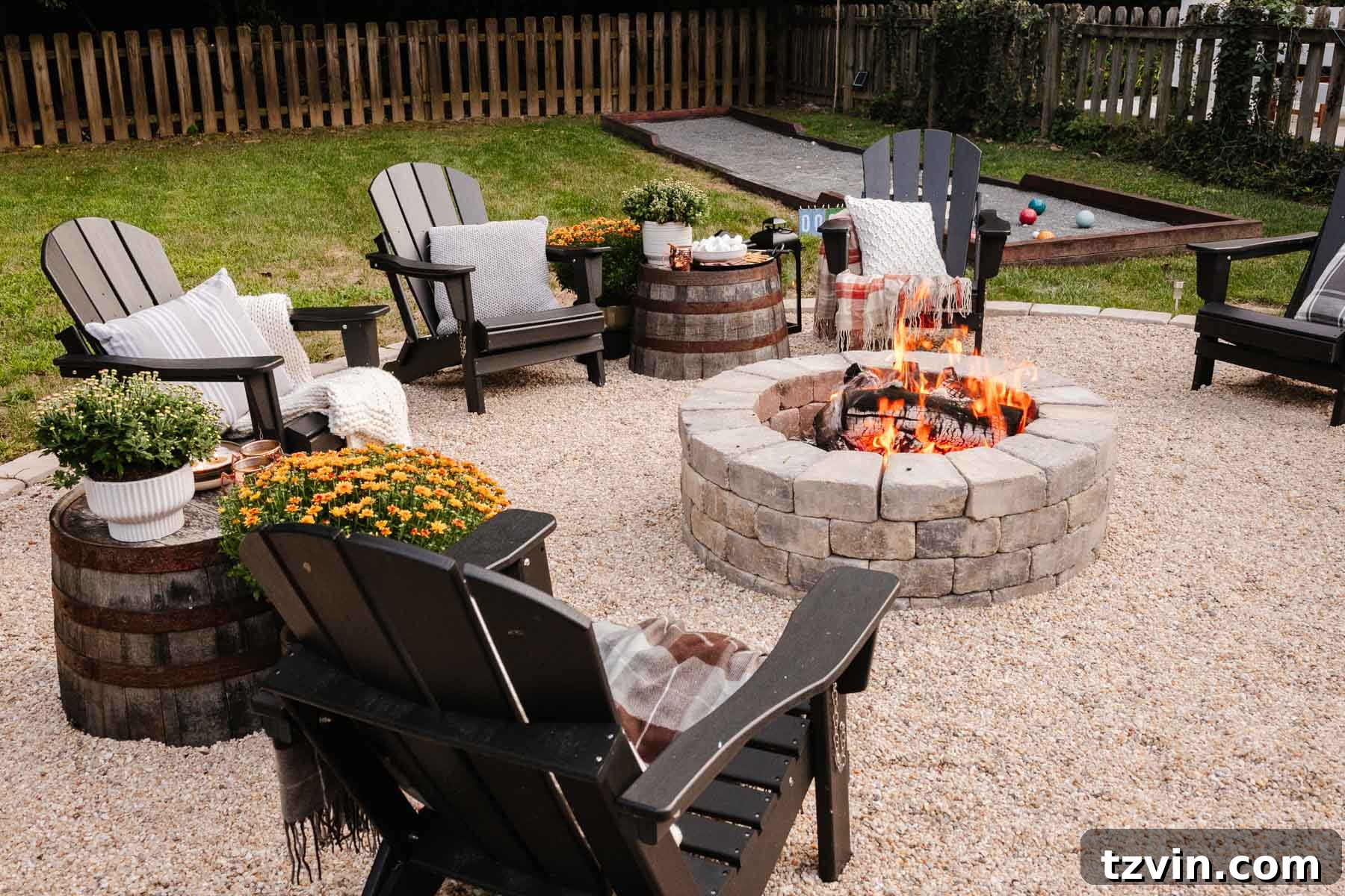 Ignite Autumn Nights: 8 Fire Pit Decor Ideas for Your Backyard 6 Backyard fire pit with fall decor and repurposed barrel planters serving as side tables