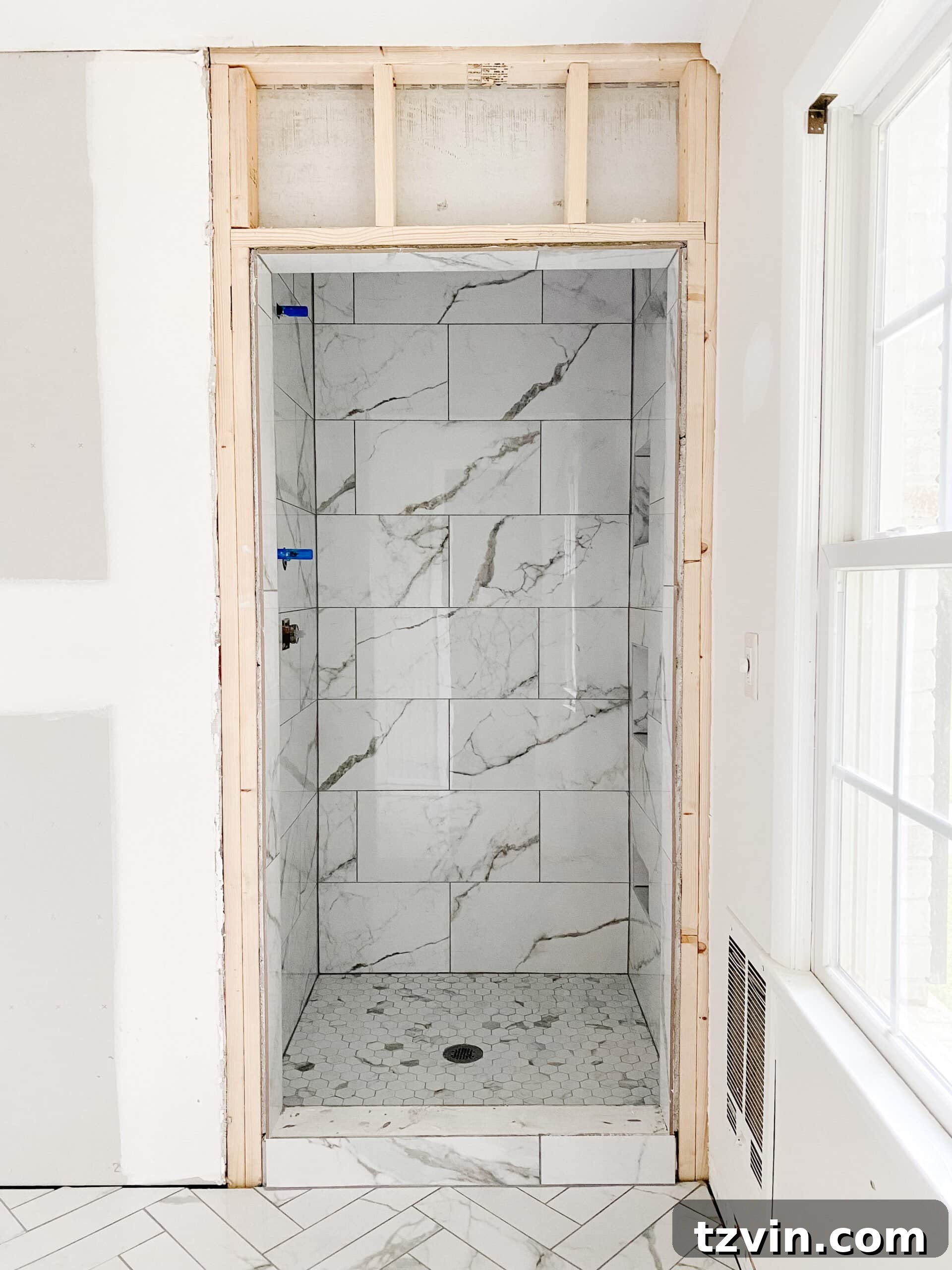 Our Faux Marble Herringbone Shower Transformation 5 newly tiled faux marble shower with sleek design