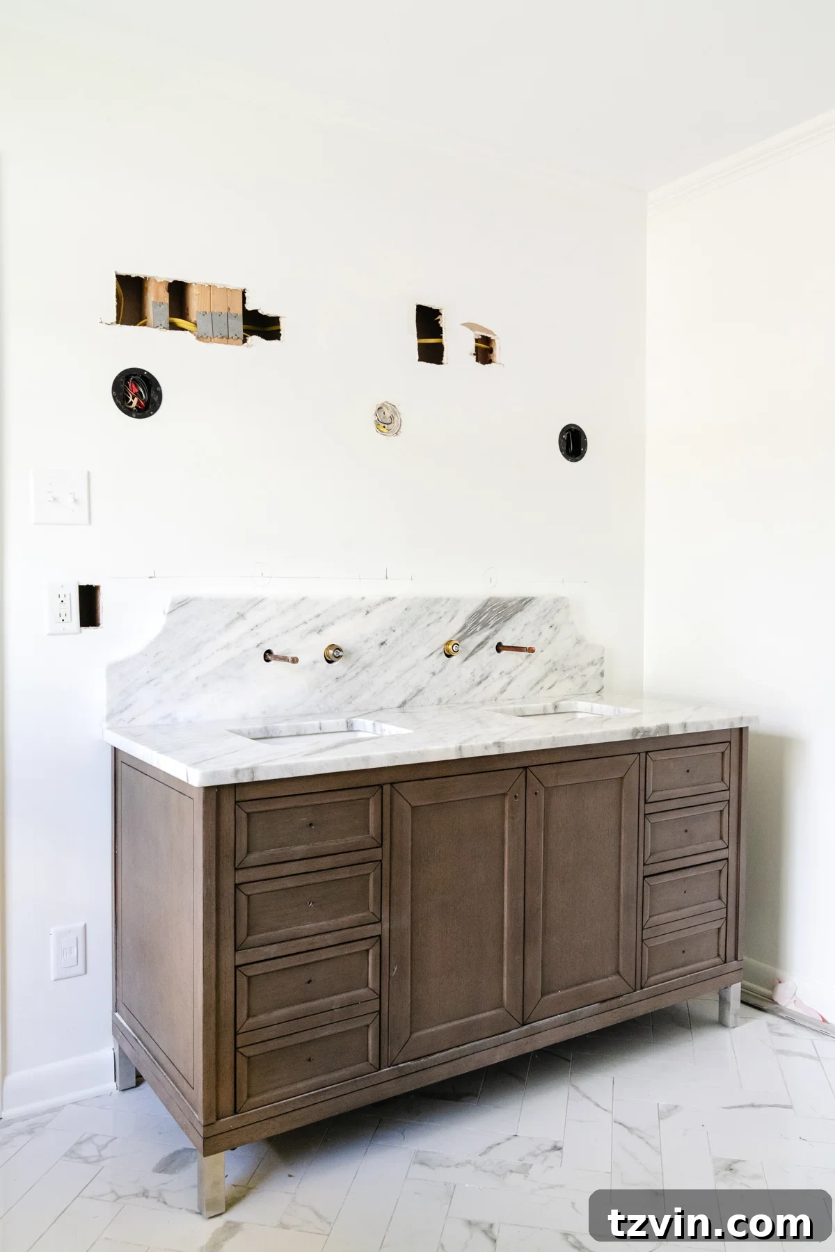 Bathroom Reno: Marble Scallop Splashback 3 Wood double vanity in a bathroom with scalloped marble backsplash and herringbone tile floor