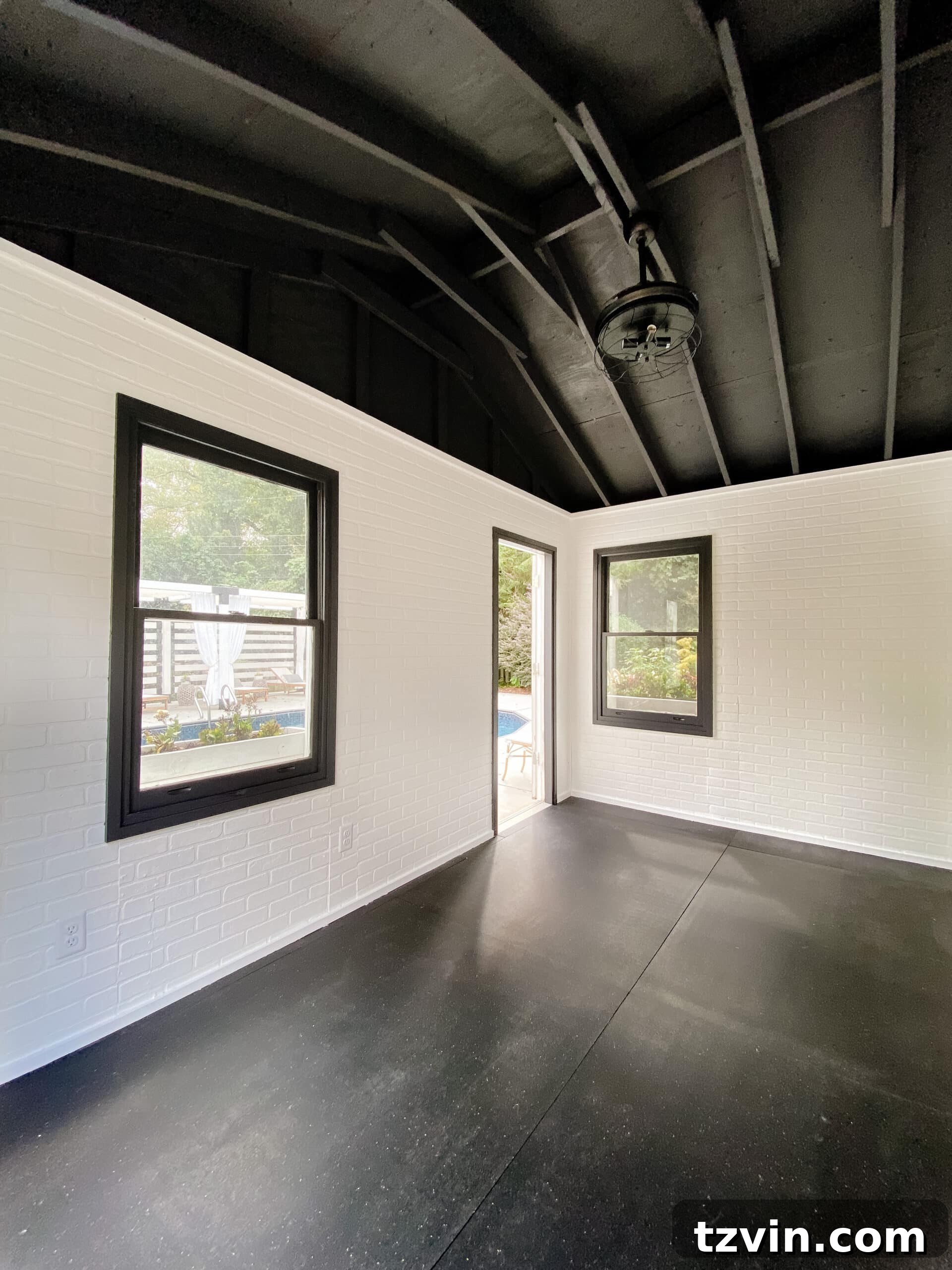 Faux Brick Gym Shed Upgrade 20 Interior of the home gym, featuring white faux brick walls, a black ceiling, and new heavy-duty rubber gym floor mats.