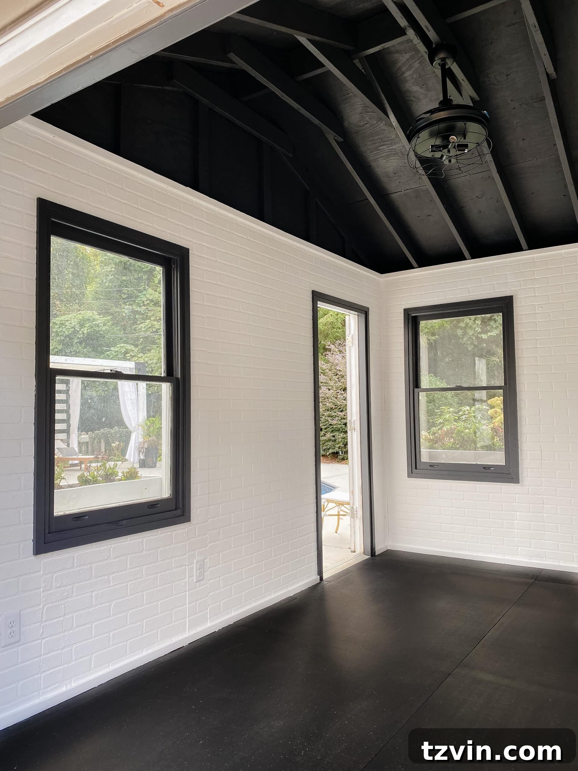 Faux Brick Gym Shed Upgrade 4 Interior view of the transformed gym shed featuring clean white faux brick wall panels and a contrasting black ceiling, creating an industrial aesthetic.