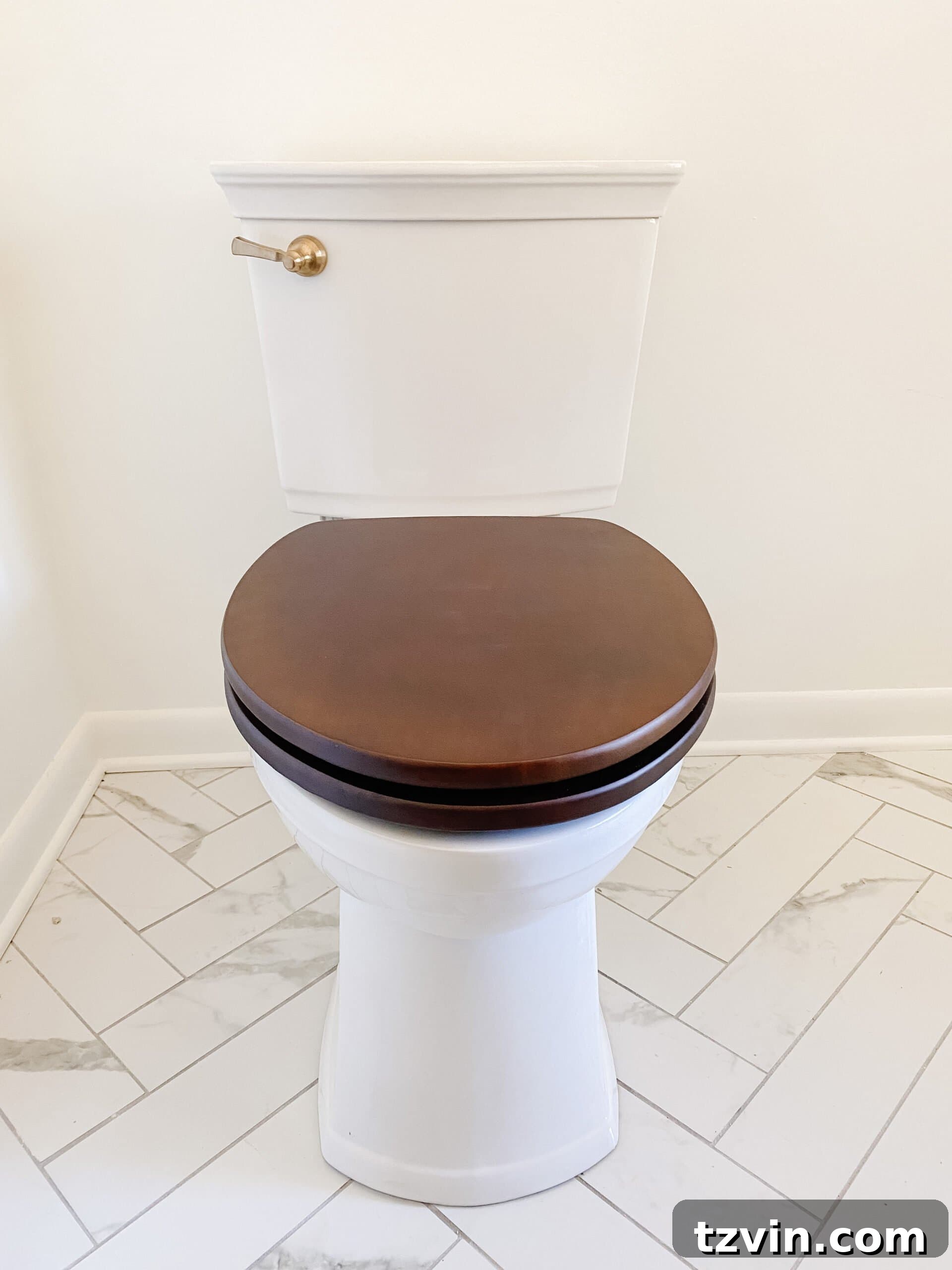 En Suite Bathroom Renovation: Faucets Are Finally Here! 6 Close-up of a toilet featuring a warm wooden toilet seat and a sophisticated gold flush lever, highlighting classic details.