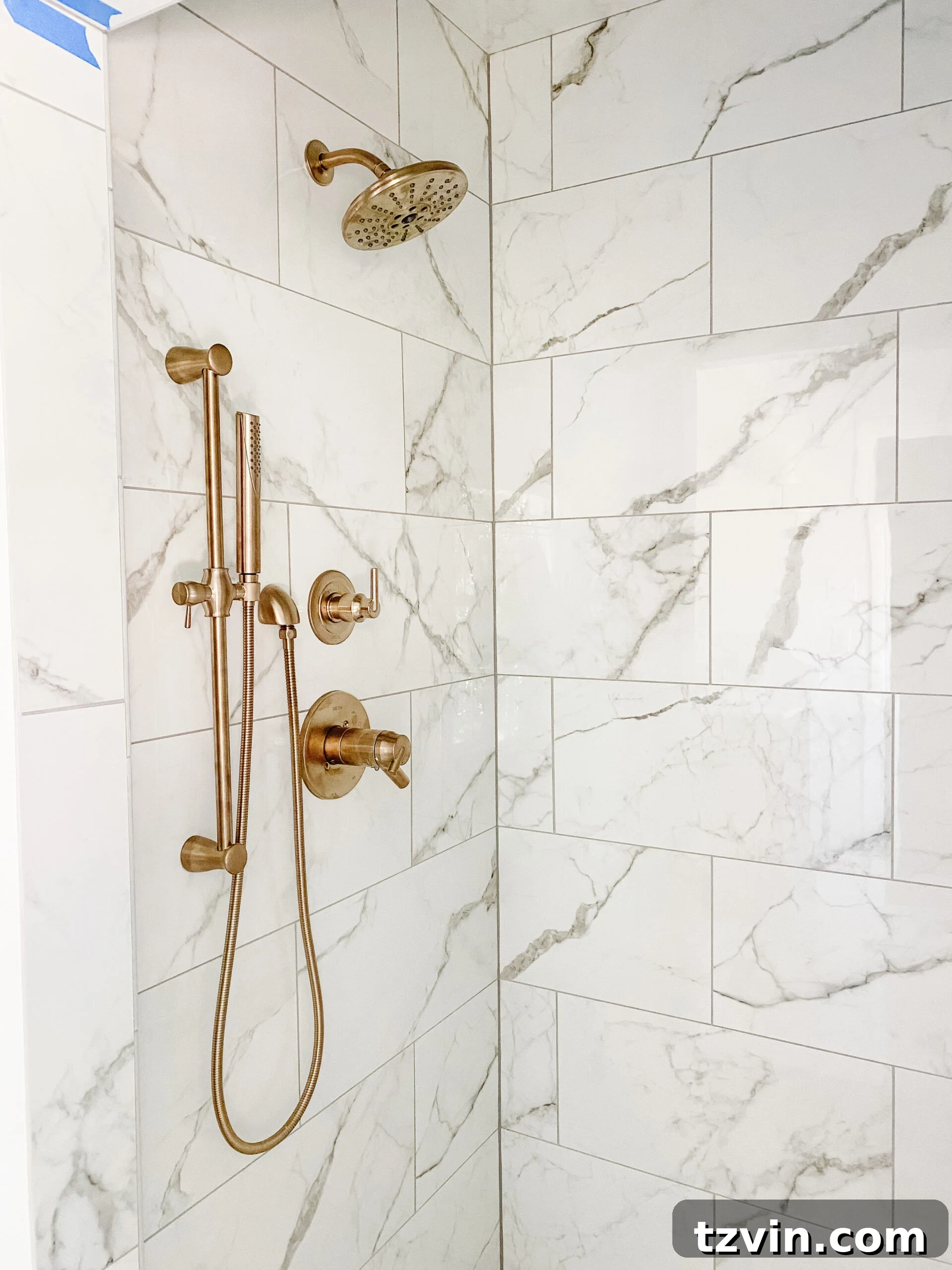 En Suite Bathroom Renovation: Faucets Are Finally Here! 9 Close-up of elegant Champagne Bronze shower faucets with a practical slide bar and hand shower in the en suite bathroom.