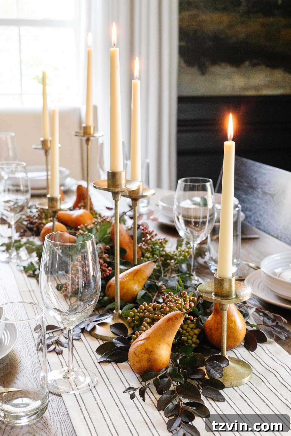 10-Minute Thanksgiving Table Makeover 3 Simple Thanksgiving table centerpiece featuring natural leafy stems, elegant taper candles, and fresh Bosc pears for a rustic, inviting look.