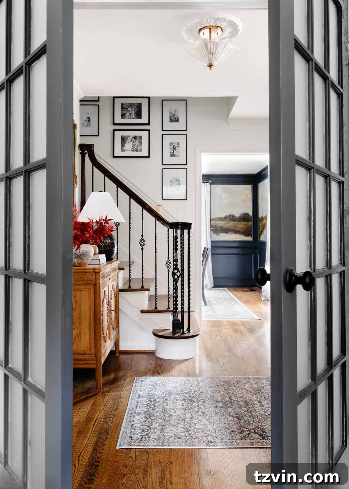 Foyer Fusion Classic Meets Contemporary 2 Foyer featuring a stylish entryway table, a welcoming rug, and a captivating stairway gallery wall
