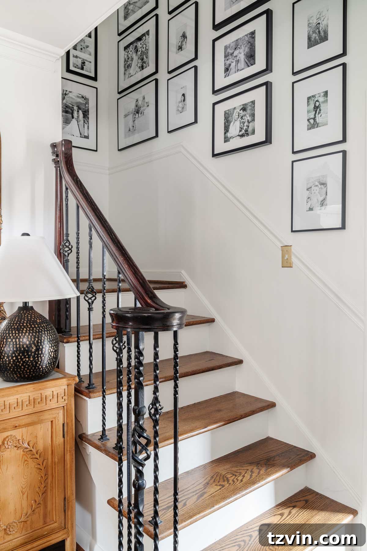 Foyer Fusion Classic Meets Contemporary 13 Elegant stairway gallery wall featuring a collection of black frames with black and white family photographs