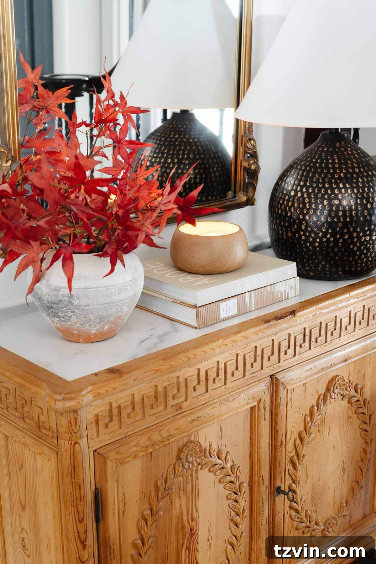 Foyer Fusion Classic Meets Contemporary 10 Detailed shot of an entryway table featuring a mirror, a lamp, and a vase with autumn leaves