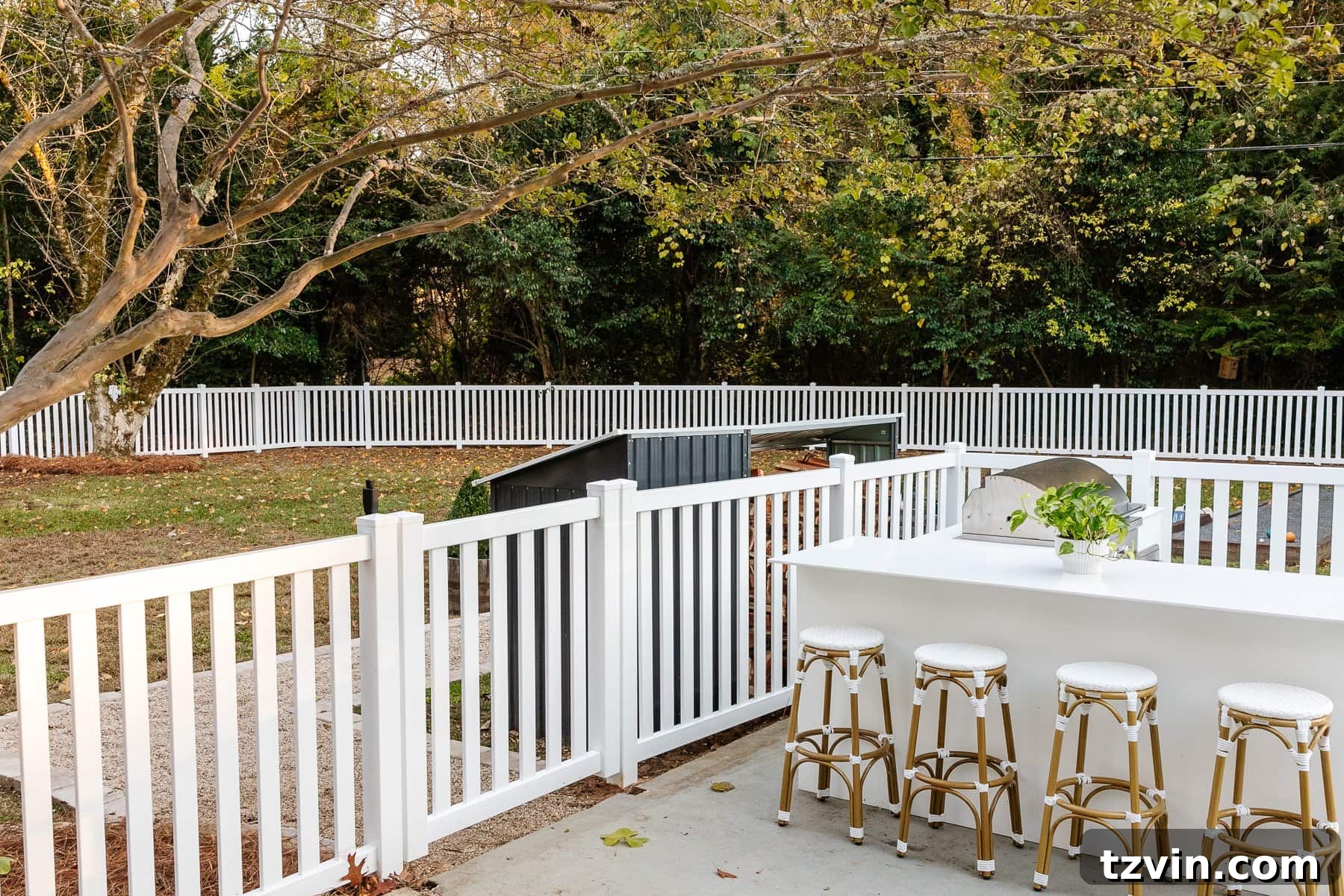 backyard with white vinyl fence and outdoor kitchen