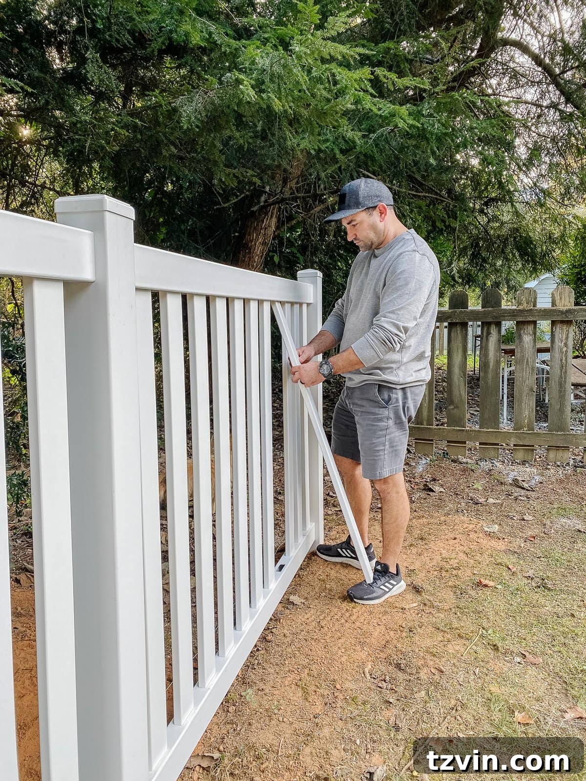 white vinyl fence installation using Ply Gem in a backyard