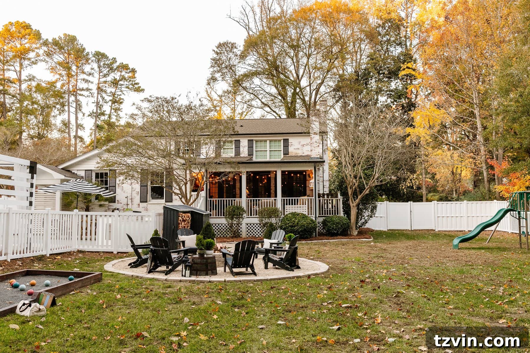 backyard with fire pit, back porch, playground, wood stack shed, and vinyl fence