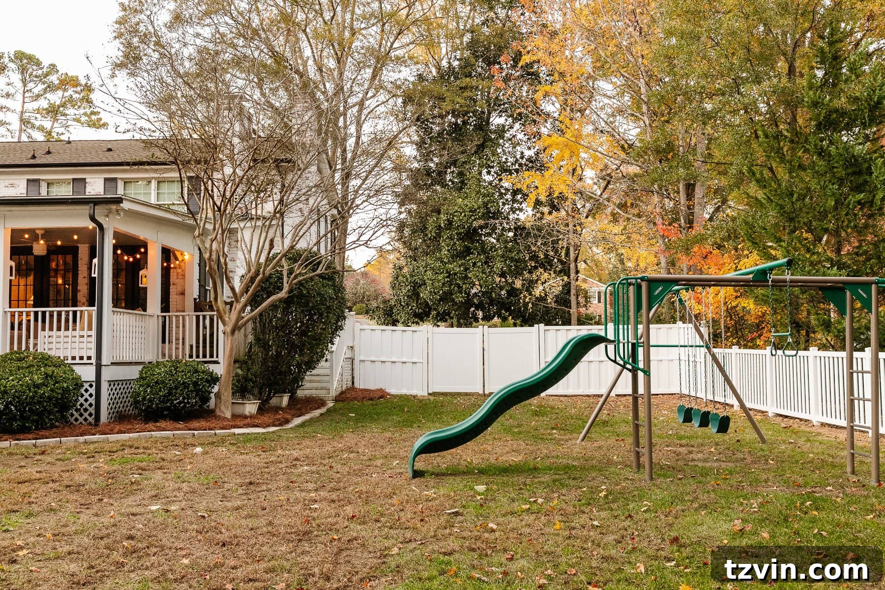 backyard with back porch, playground, and white vinyl fence