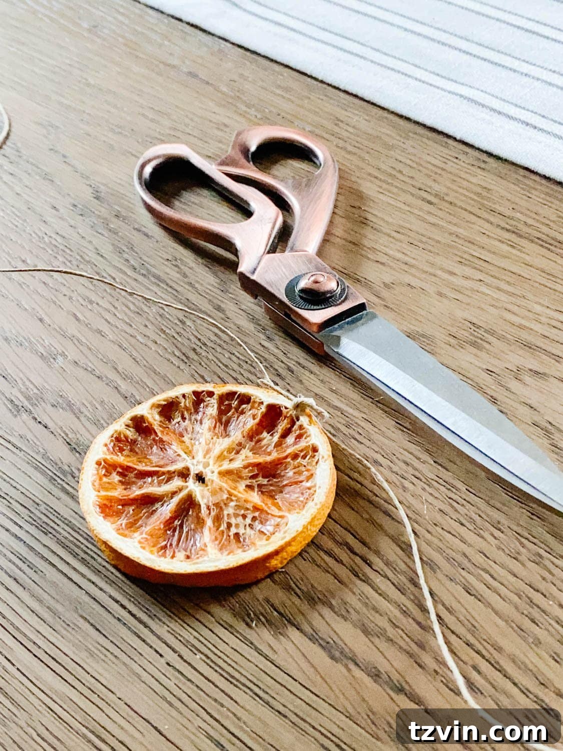 Craft Your Own Beautiful Dried Orange Garland 8 A long strand of twine with several dried orange slices already tied onto it at even intervals.