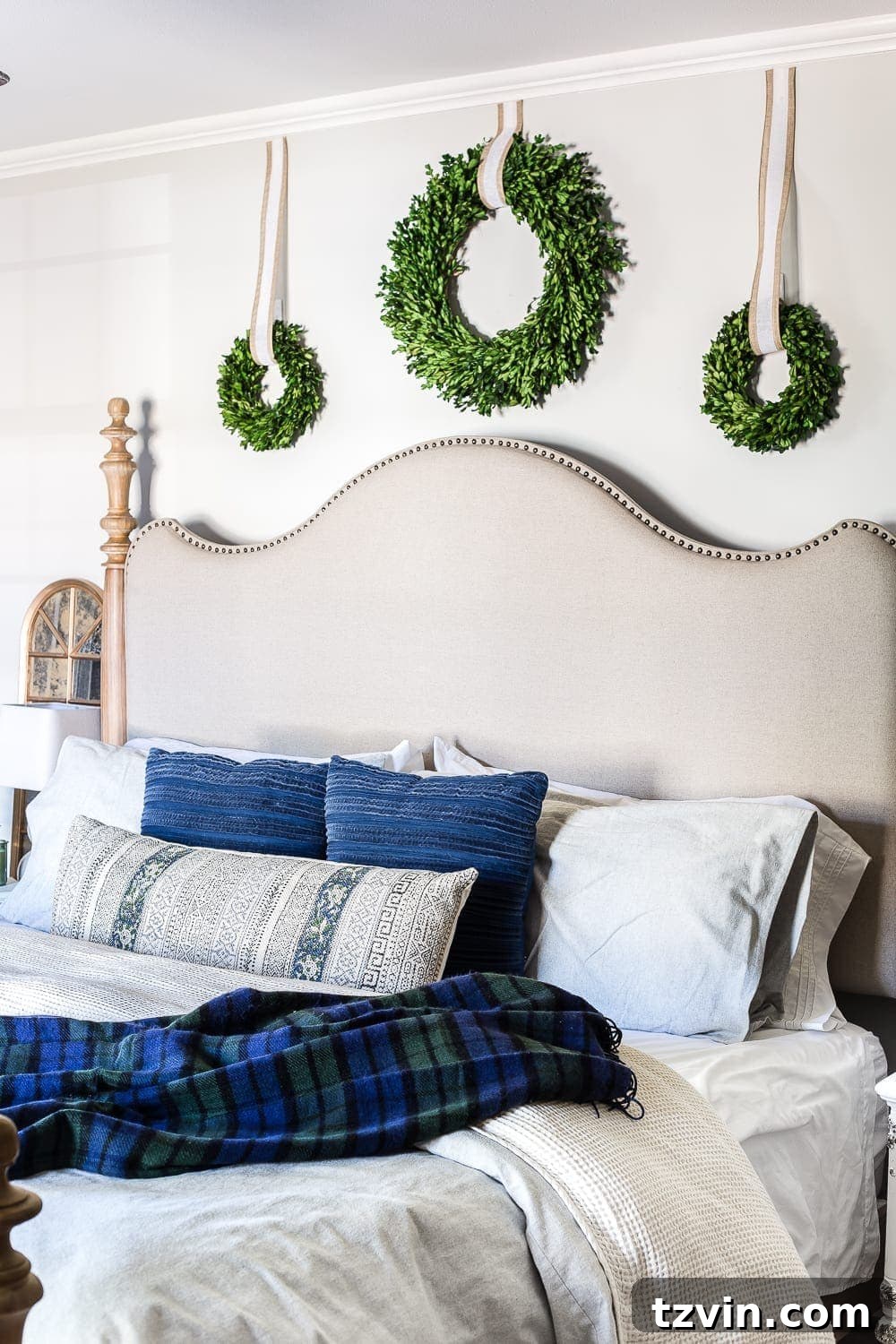 boxwood wreaths above a headboard