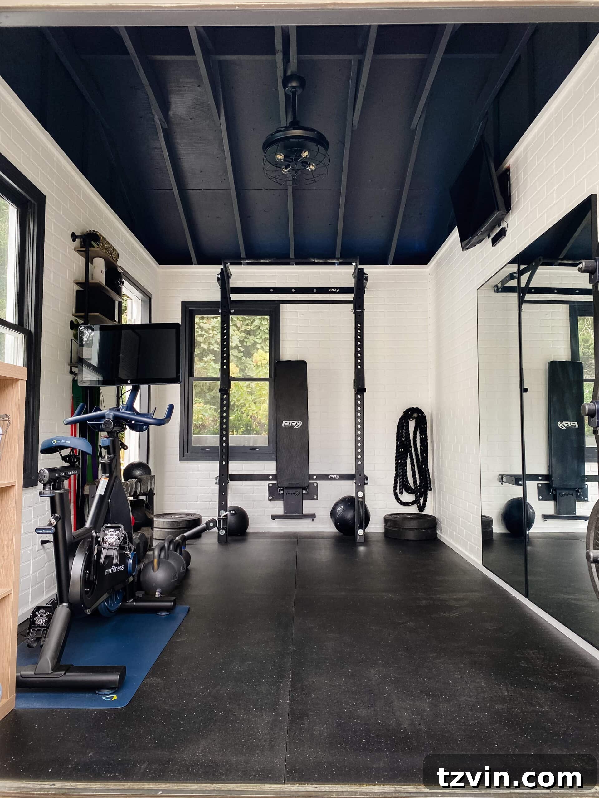 Our Favorite 21 Room Makeovers of 2021 32 After image of the home gym shed, with faux brick walls and exercise equipment.