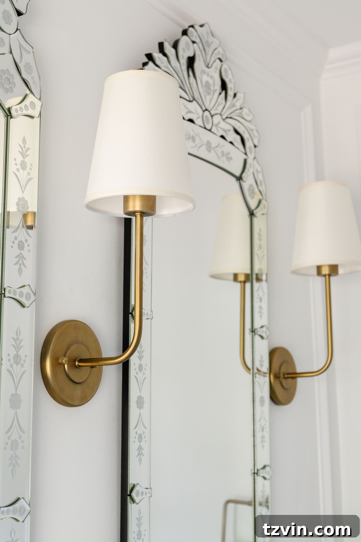 Shaded sconce lights in bathroom with Venetian mirrors
