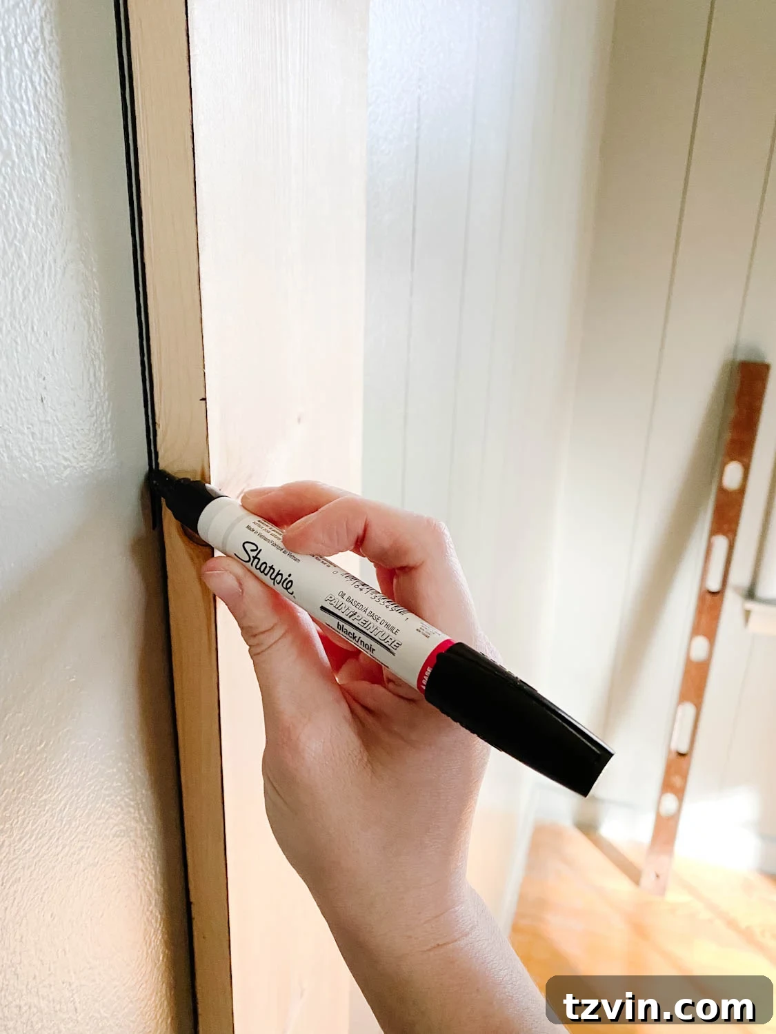 using a Sharpie paint pen to make lines for faux wall planking