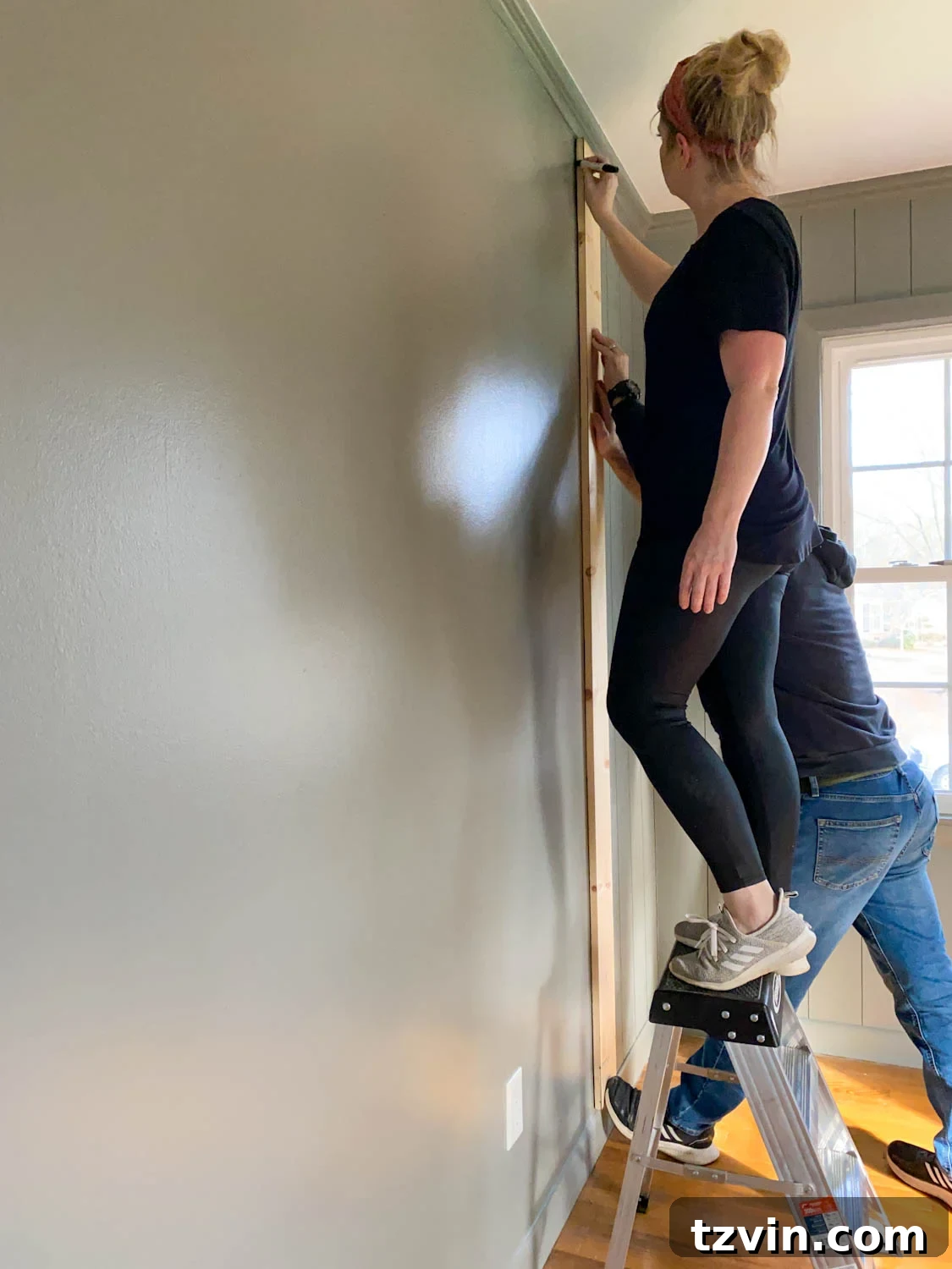 using 1x6 boards as spacers for tracing lines to mimic paneled walls with Sharpie paint pens