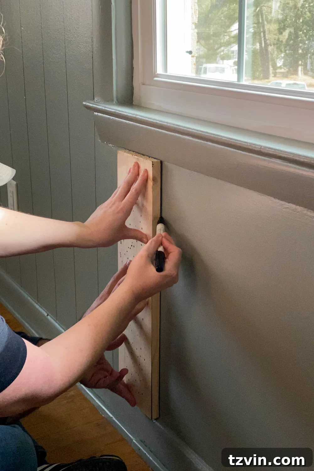 Tracing 1x6 boards with Sharpie paint pens for faux paneled walls under a window