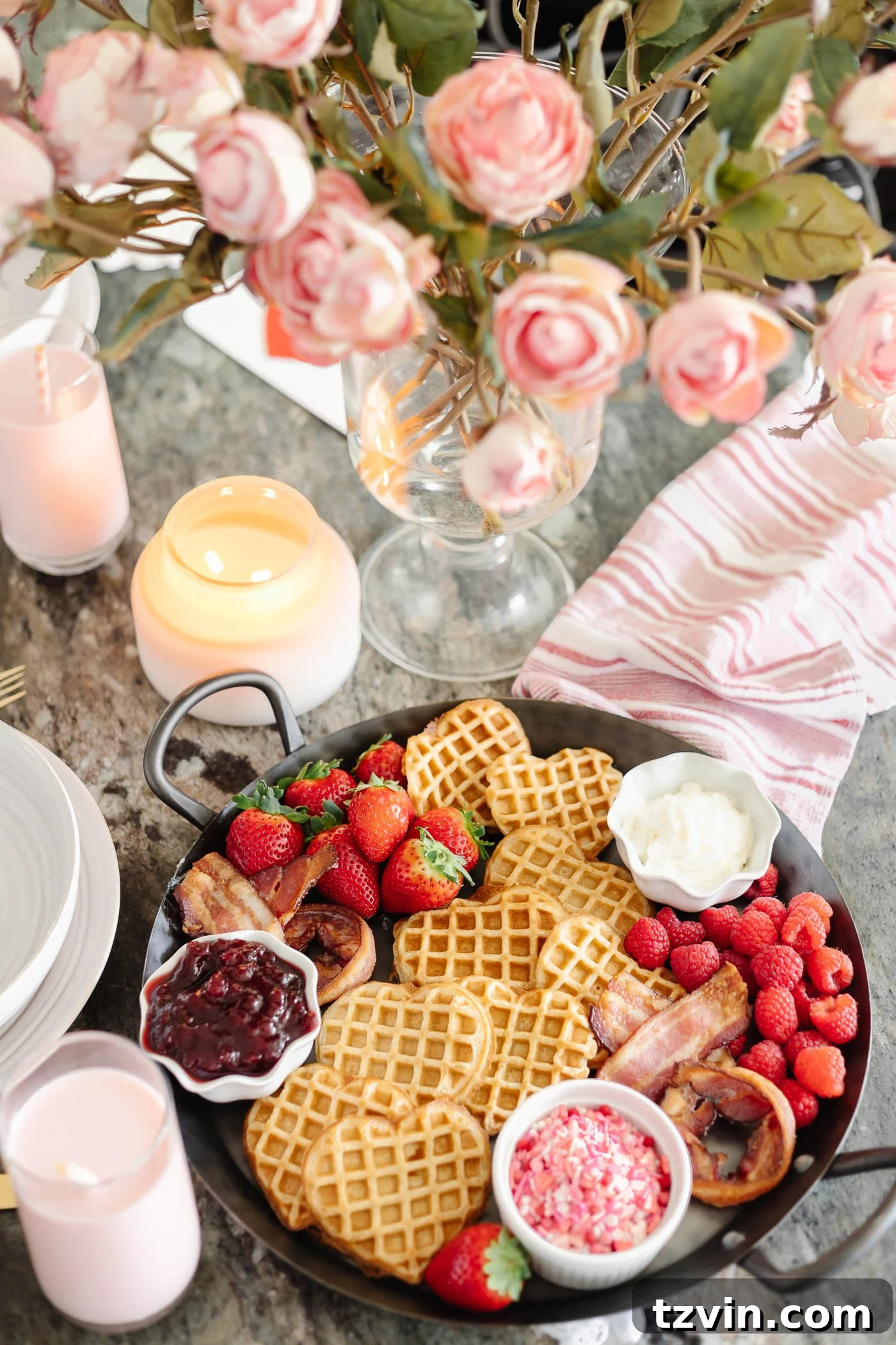 Romantic Morning Feast Board 5 Valentine's Day breakfast charcuterie board with heart shaped waffles, XO bacon, berries, and condiments with flowers and candles