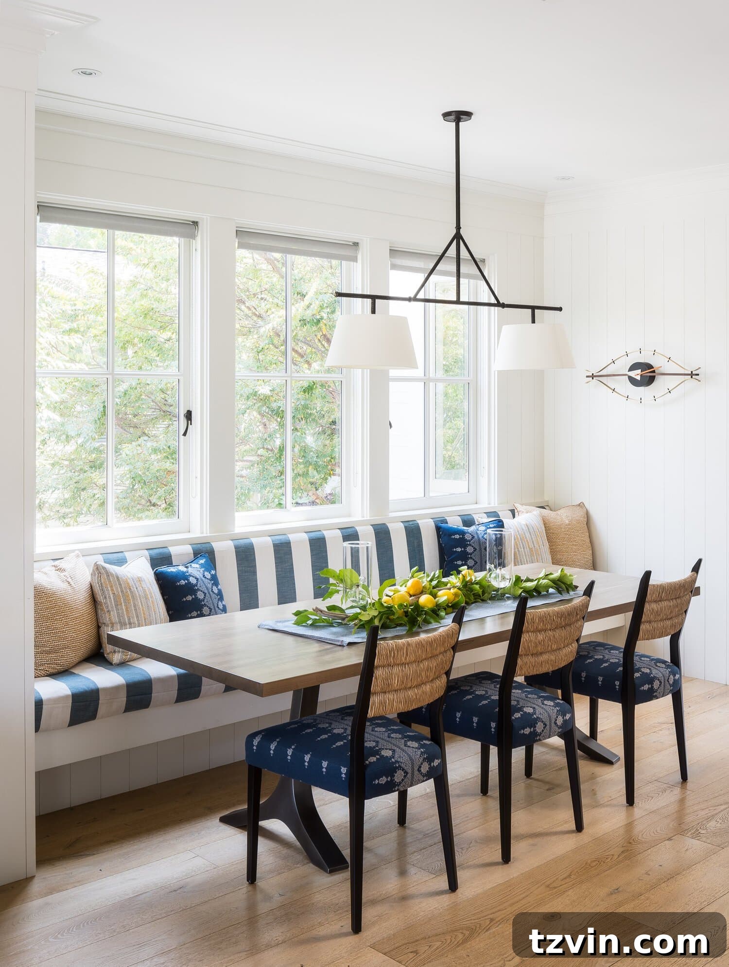 Breakfast nook seating built under windows with striped upholstery for charming dining