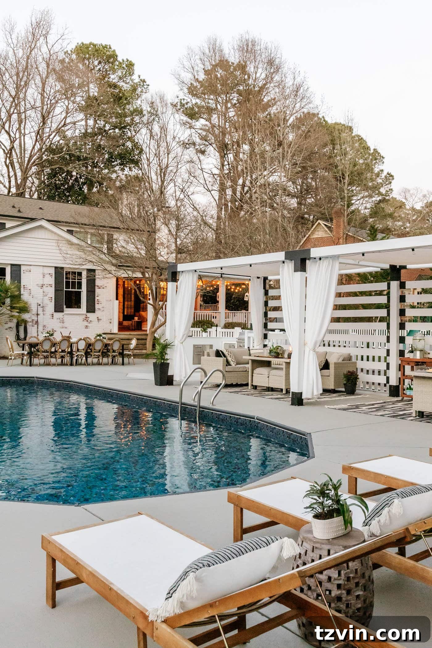 Panoramic view of the fully transformed backyard pool and patio, featuring the DIY pool cabana and limewashed brick house, showcasing all completed projects