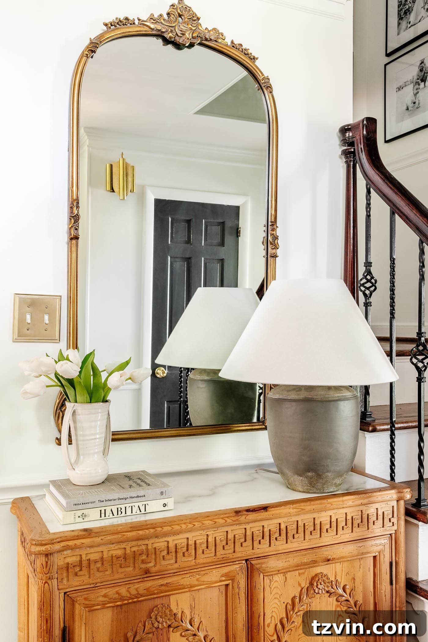 Mastering Your Entry Table Decor A Pros Step-by-Step Guide 7 adding a stack of books underneath a vase of flowers as risers for height in decorating a foyer table