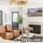 Our Top-Rated Fandelier Favorites 7 Elegant glass and gold fandelier in a living room with limewashed brick fireplace, white walls, and black doors, offering a refined aesthetic.