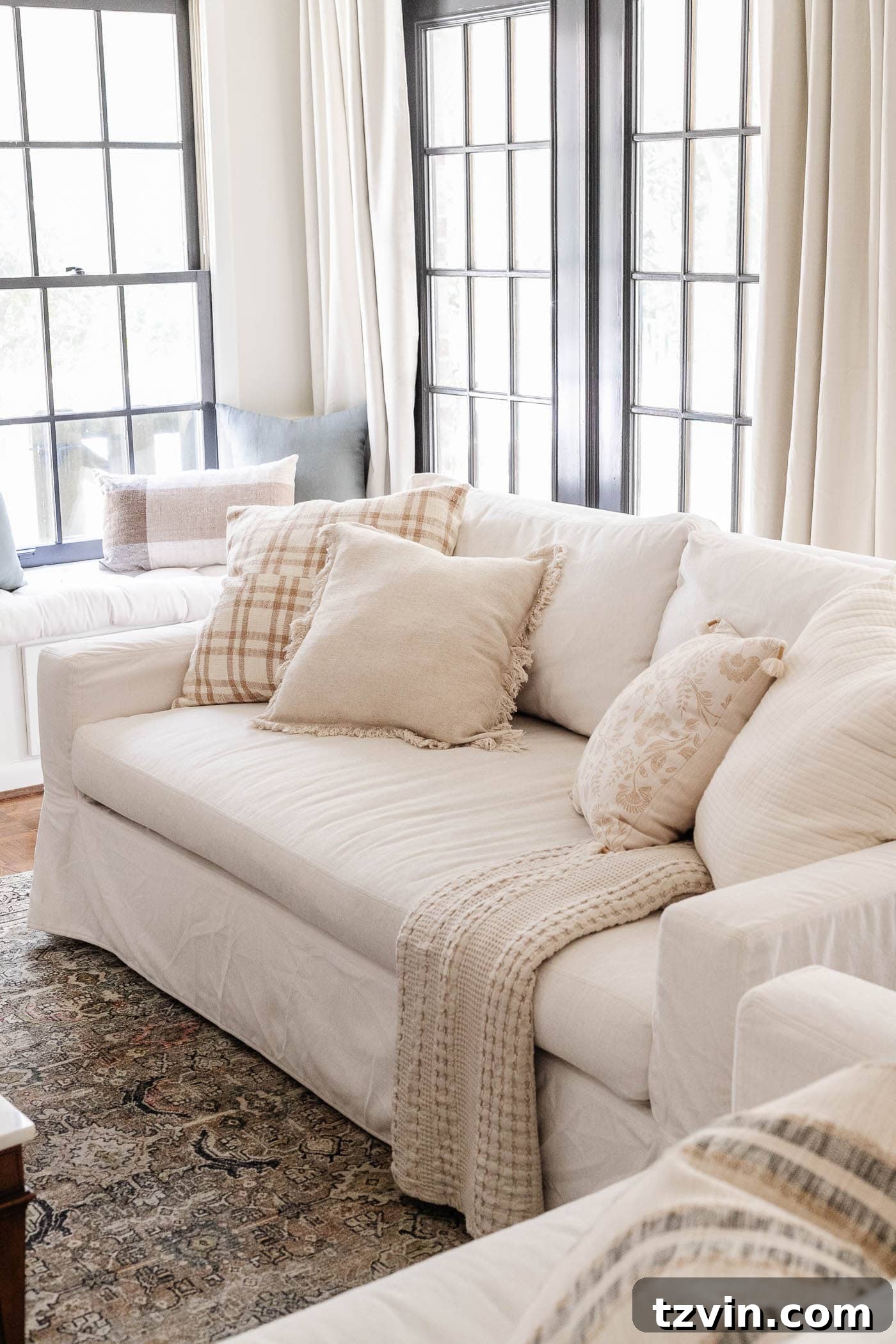30 Budget Secrets to a Million-Dollar Home Aesthetic 22 white Pottery Barn York sofa in a living room with black French doors and linen curtains