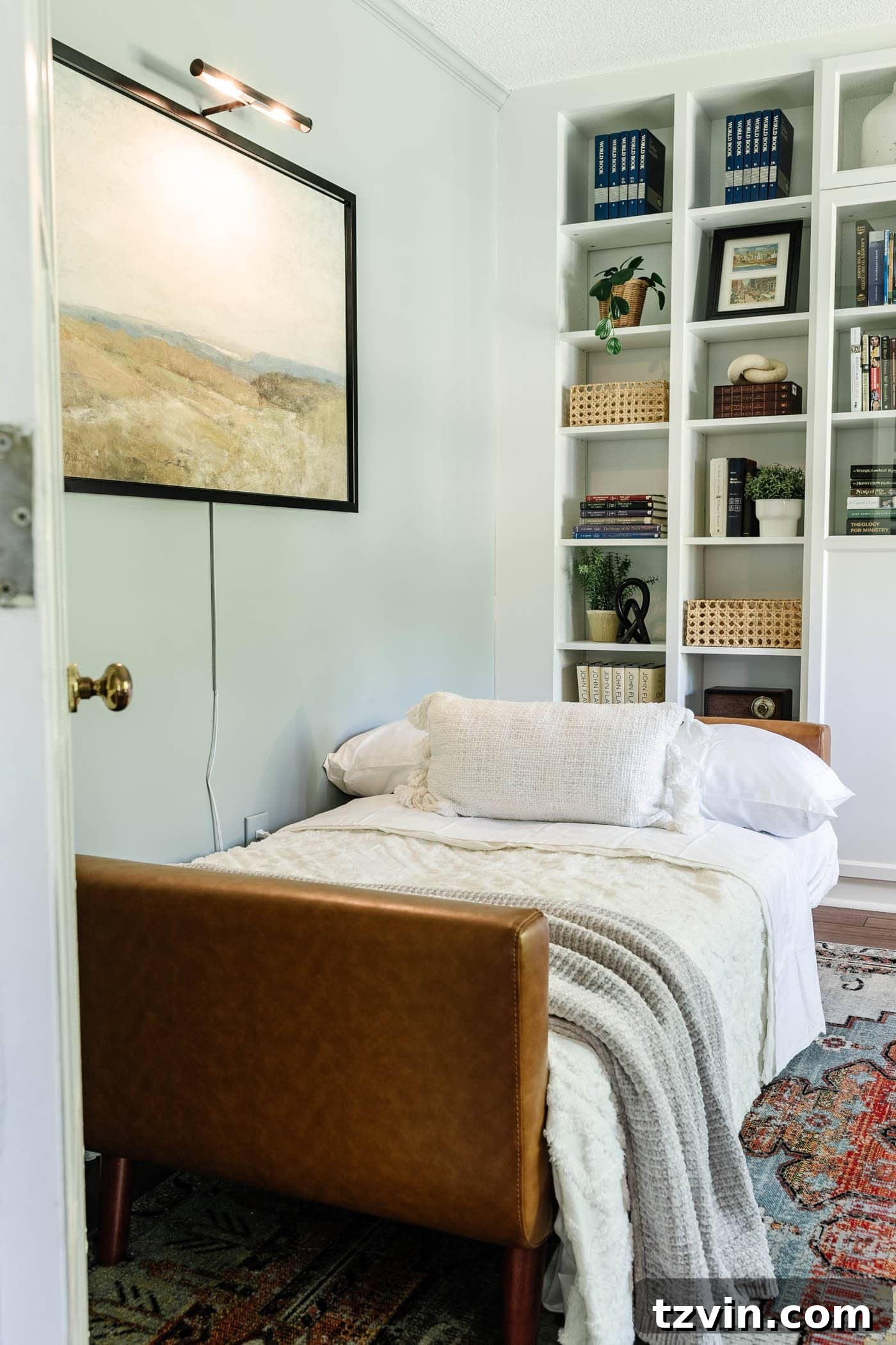 A home office temporarily converted into a guest bedroom, featuring a futon with inviting bedding.