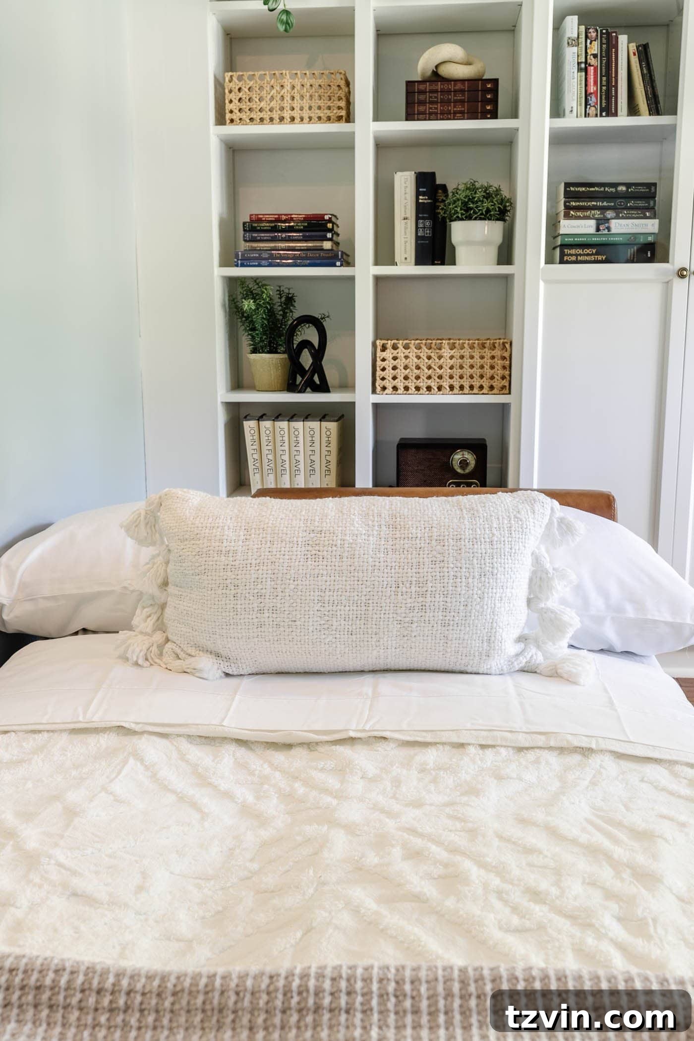Comfortable guest bedding adorned with stylish throw pillows on a futon in an office setting.