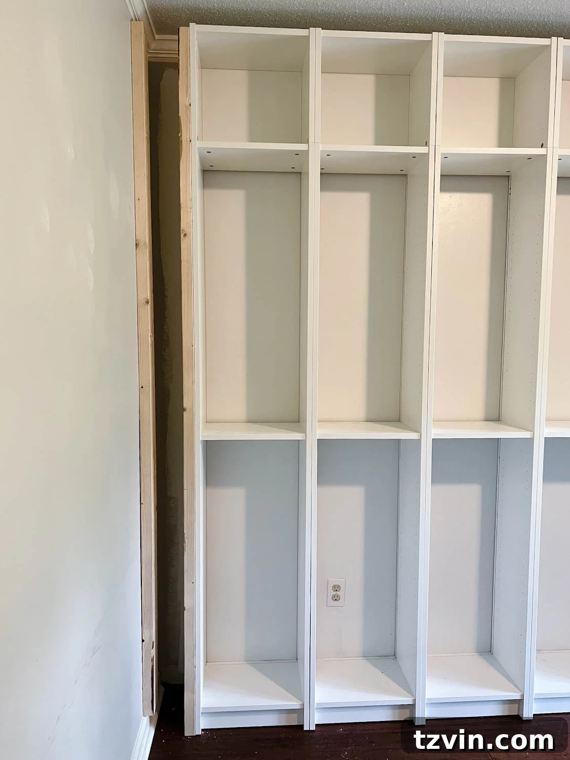 using 2x4 boards to brace sides and fill gaps to make bookcases look built in for the IKEA Billy bookcase hack