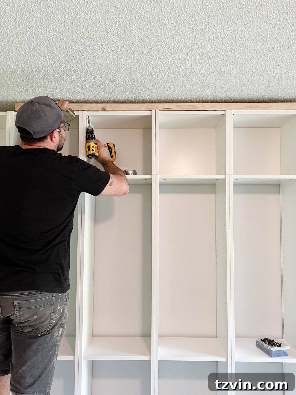 Building Custom Bookshelves with IKEA Billy Bookcase Hacks 14 adding a 2x4 board to the top of bookcases to fill the gap below the ceiling for DIY built in bookshelves
