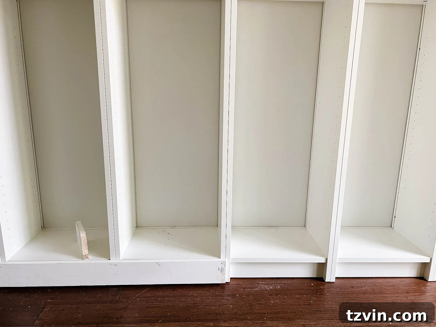 Building Custom Bookshelves with IKEA Billy Bookcase Hacks 15 adding 1x4 boards to the bottom of bookcases to make them look flush for DIY built in bookshelves