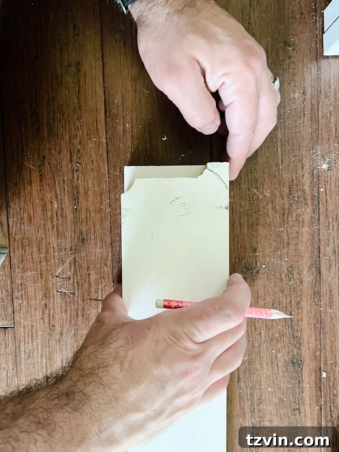 Building Custom Bookshelves with IKEA Billy Bookcase Hacks 16 marking the shape of a baseboard to a 1x4 board to cut