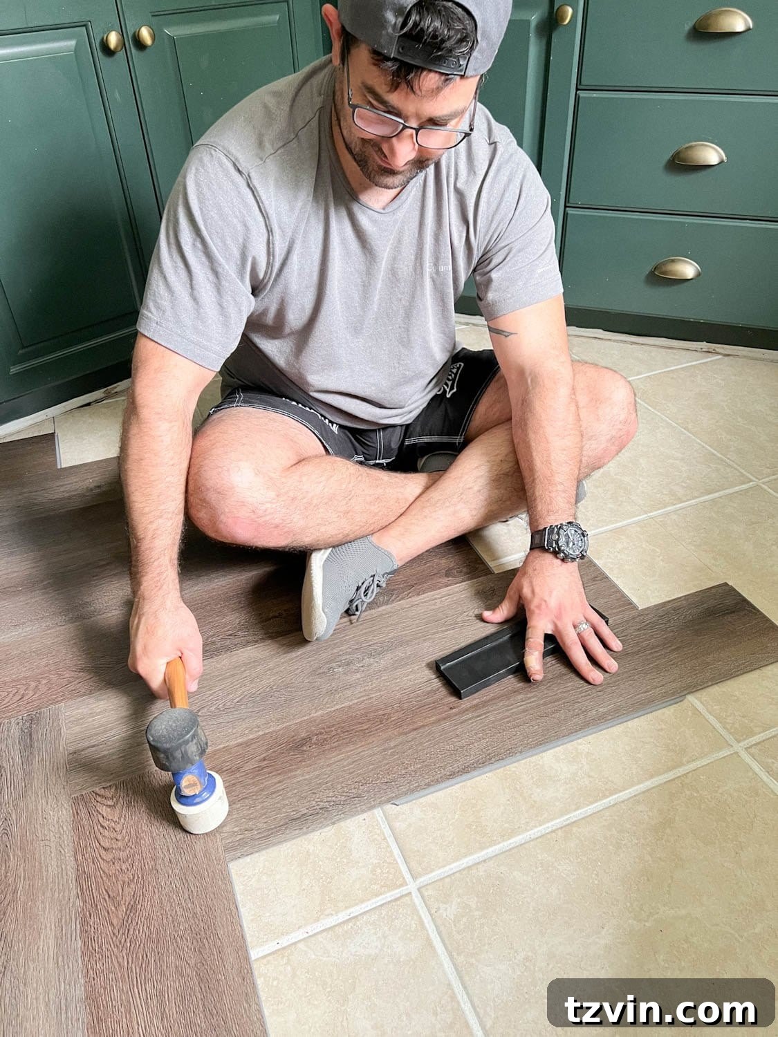using a mallet to click LVP flooring into place during installation