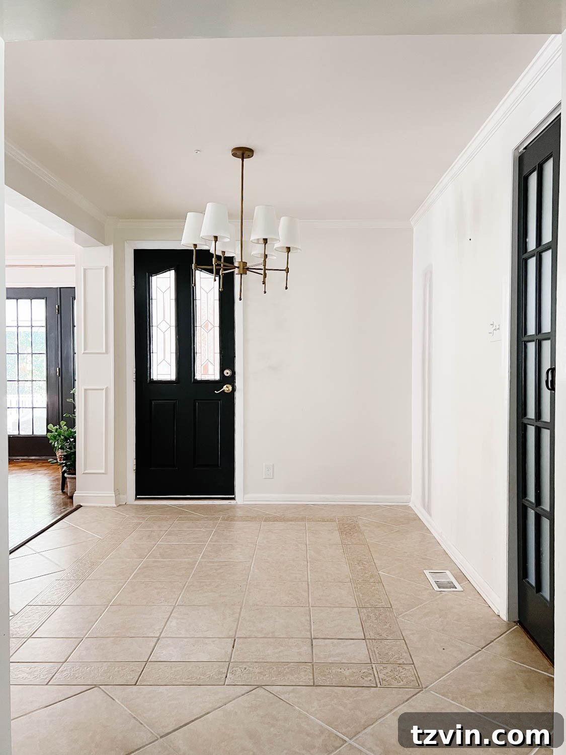 beige tile floor in a breakfast room with white walls and black doors